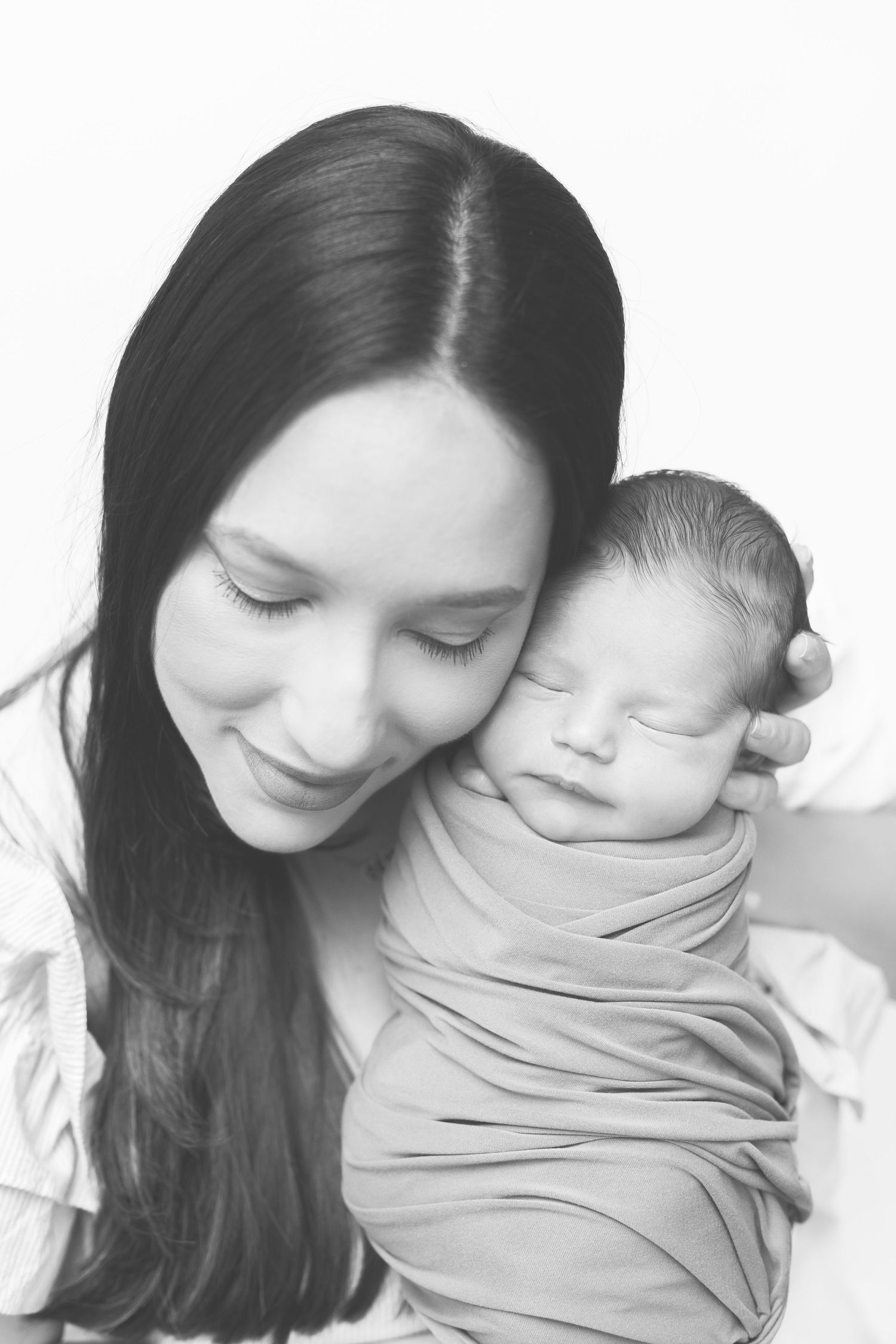 Black and white portraits showing intimate bonding moments with sleeping infant.