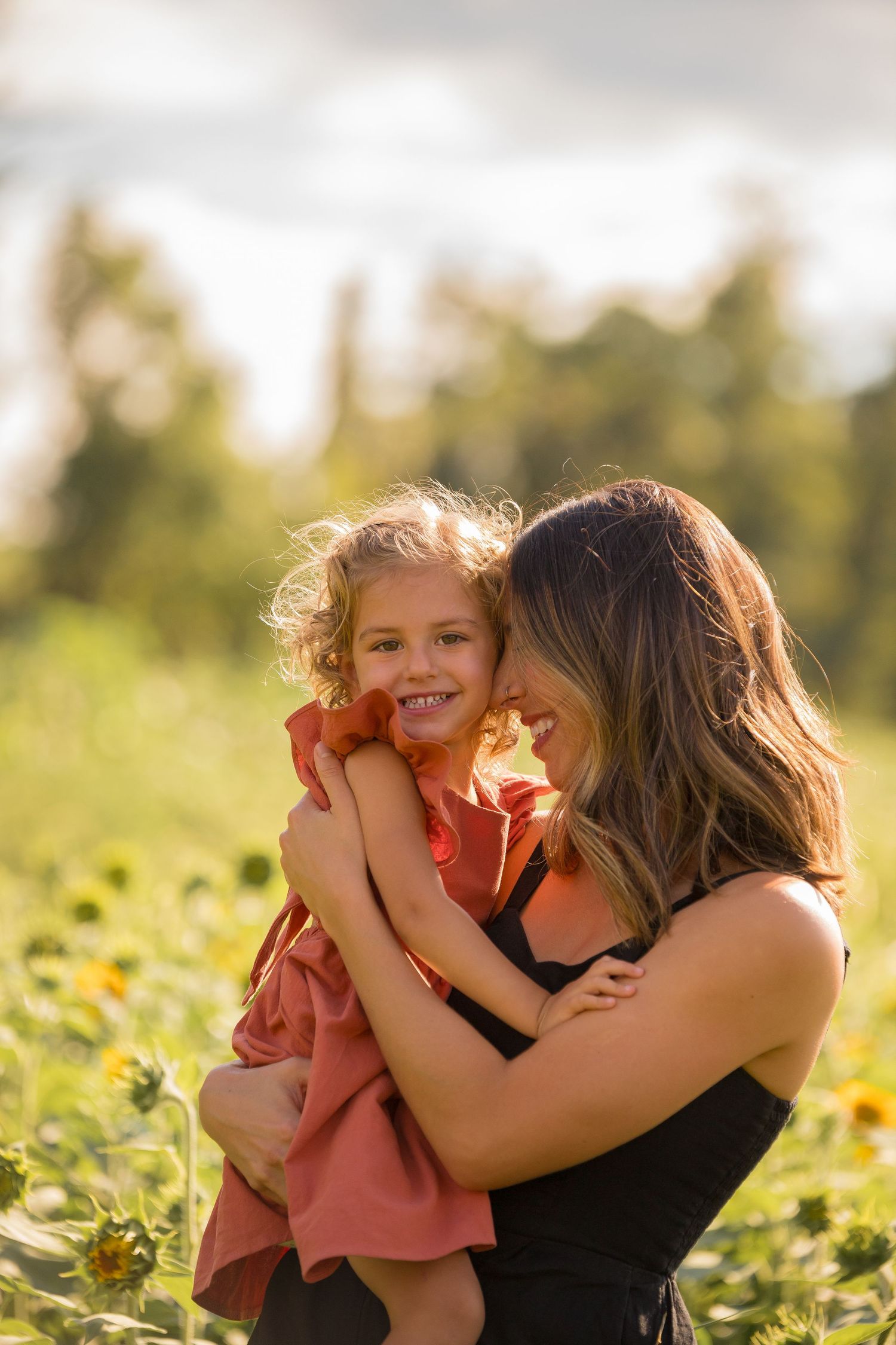 Tender moments shared among family members in a sunny flower field.