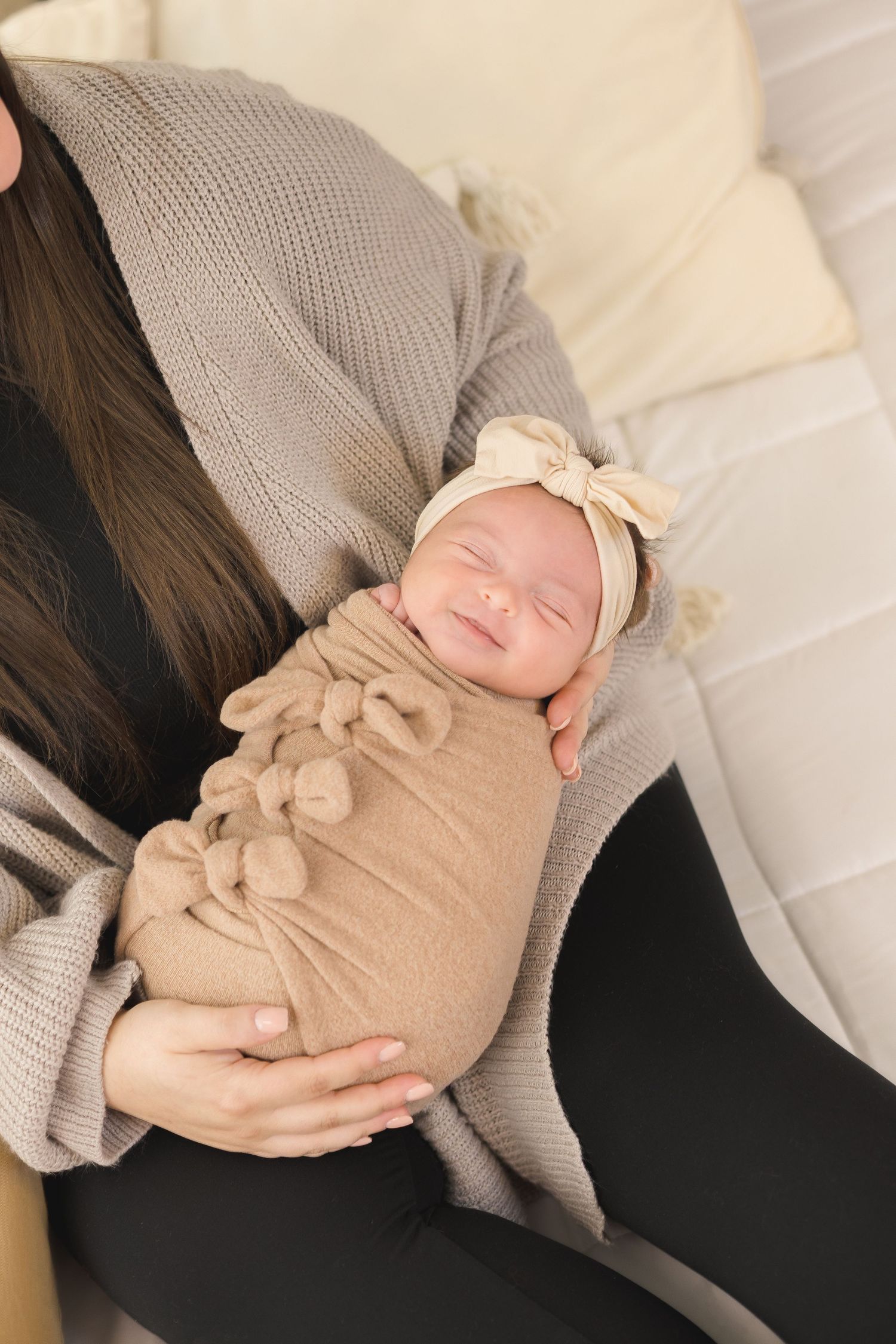 A series of pregnancy progression photos showing a growing baby bump in neutral beige and cream colored clothing.