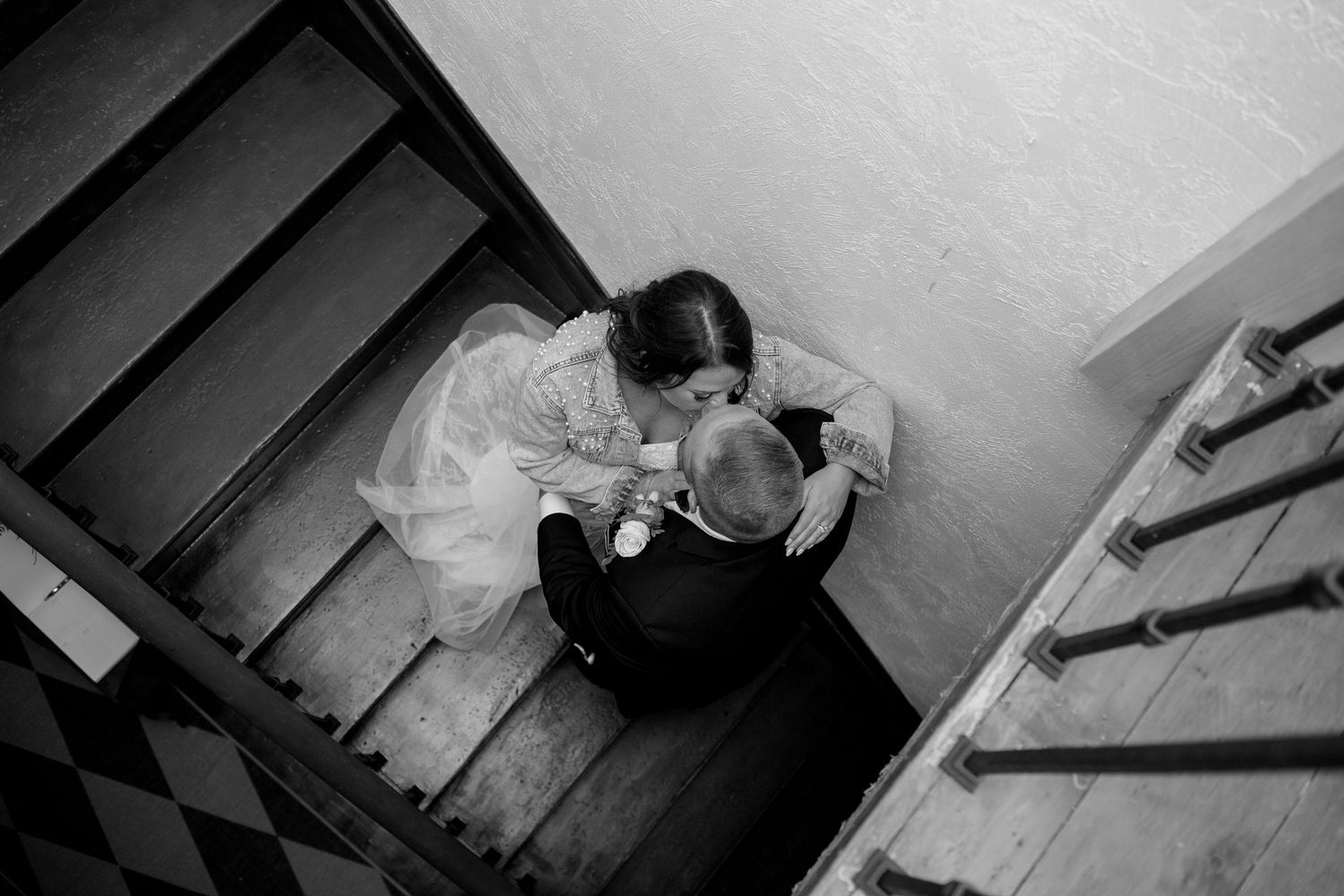 Black and white photo of someone sitting alone on stairs in a contemplative pose.