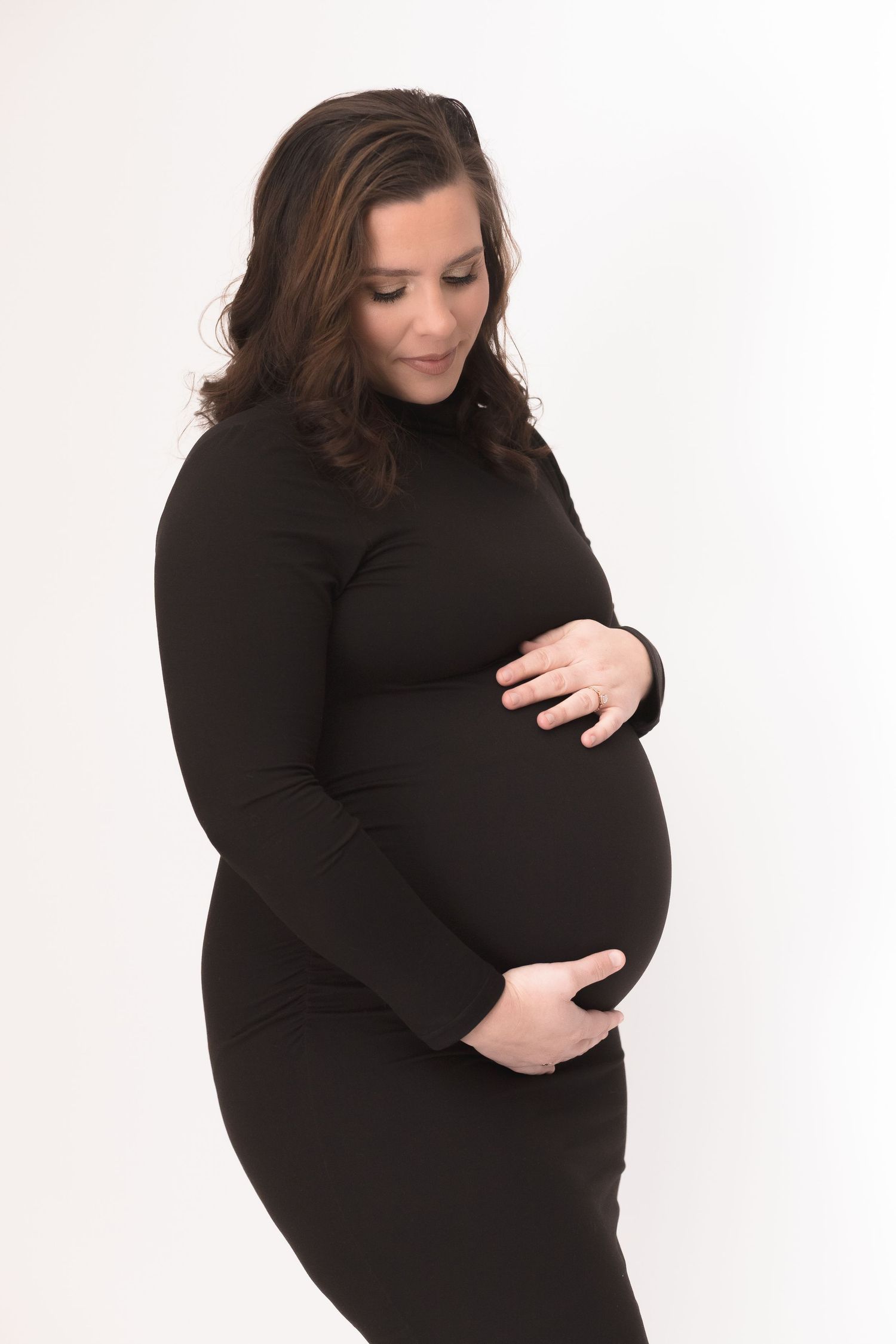 Classic black maternity photos on white backdrop showing pregnancy silhouette.