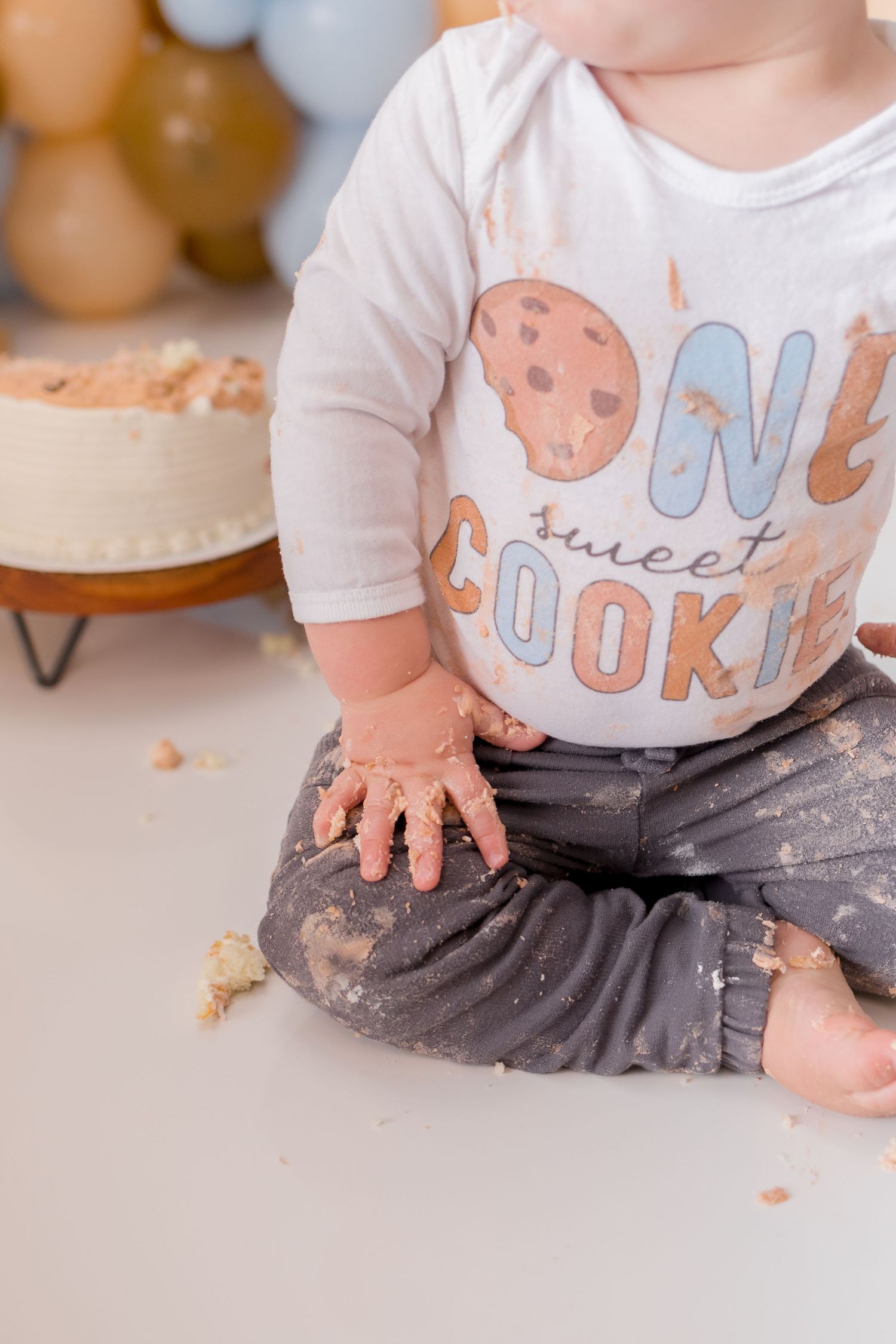 Close-up of cookie-themed shirt and messy cake smash celebration details.