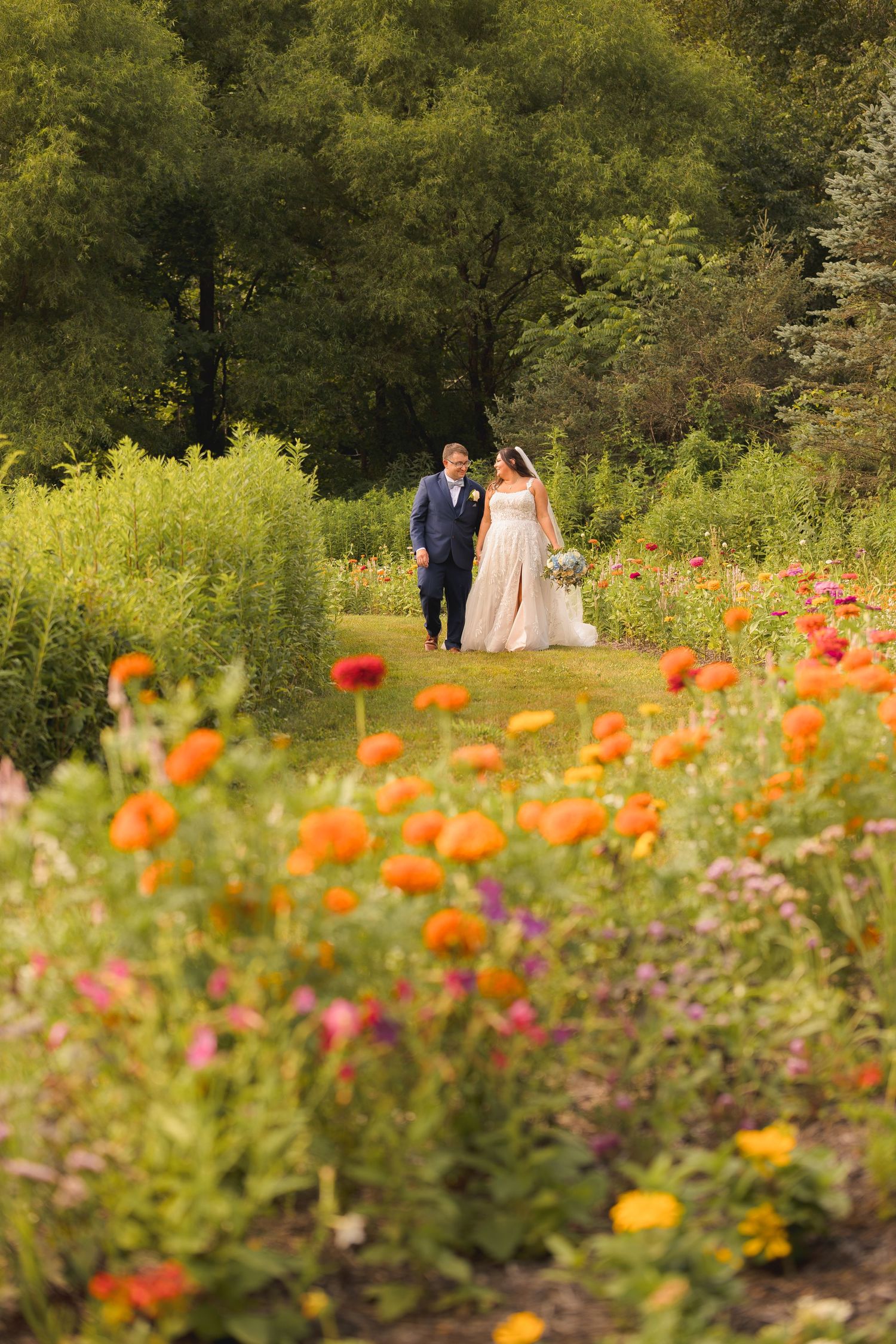 Colorful wildflower garden with couple walking among orange and pink blooms.