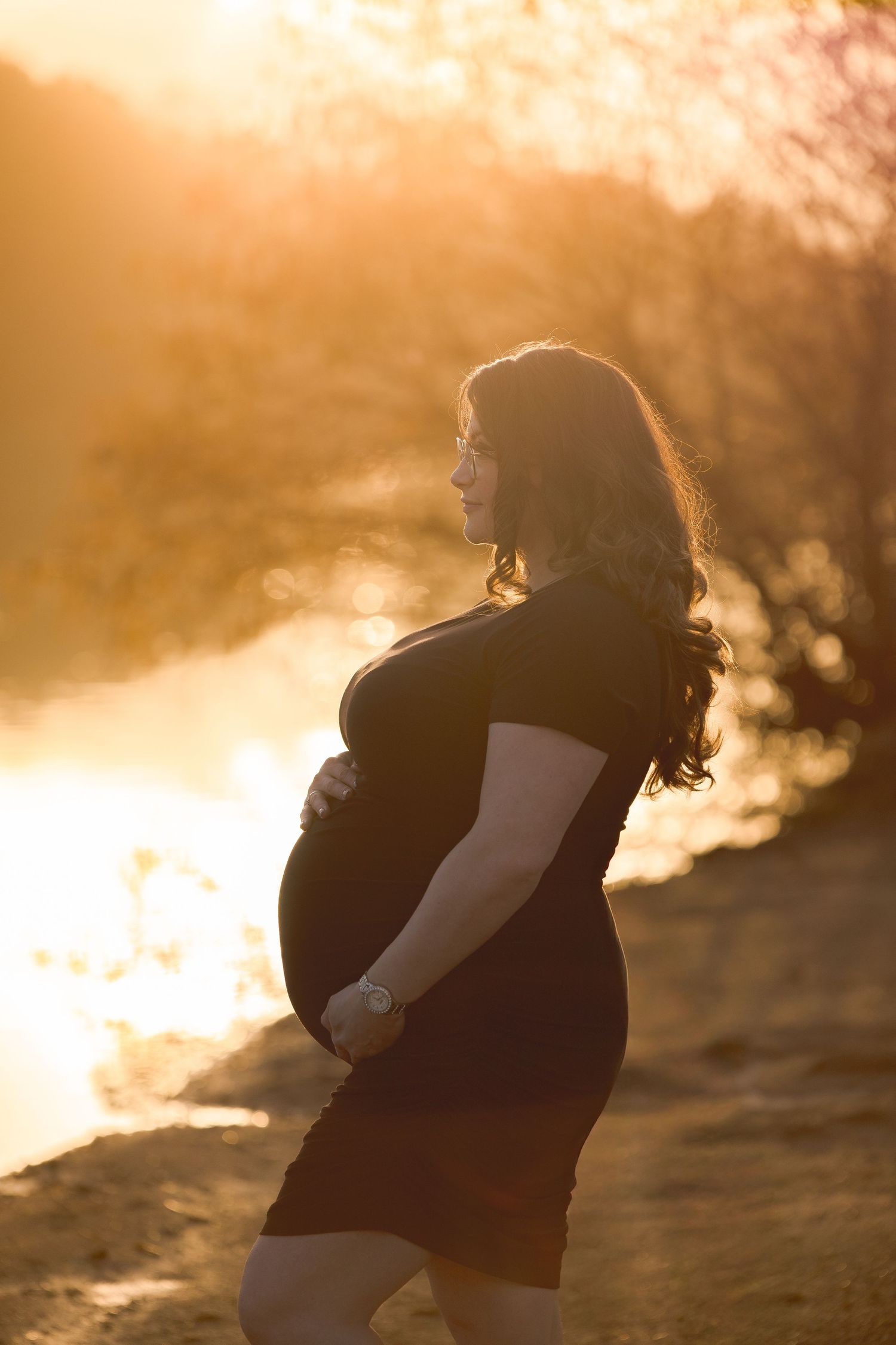 Silhouetted maternity photos at golden hour sunset showing pregnancy profile.