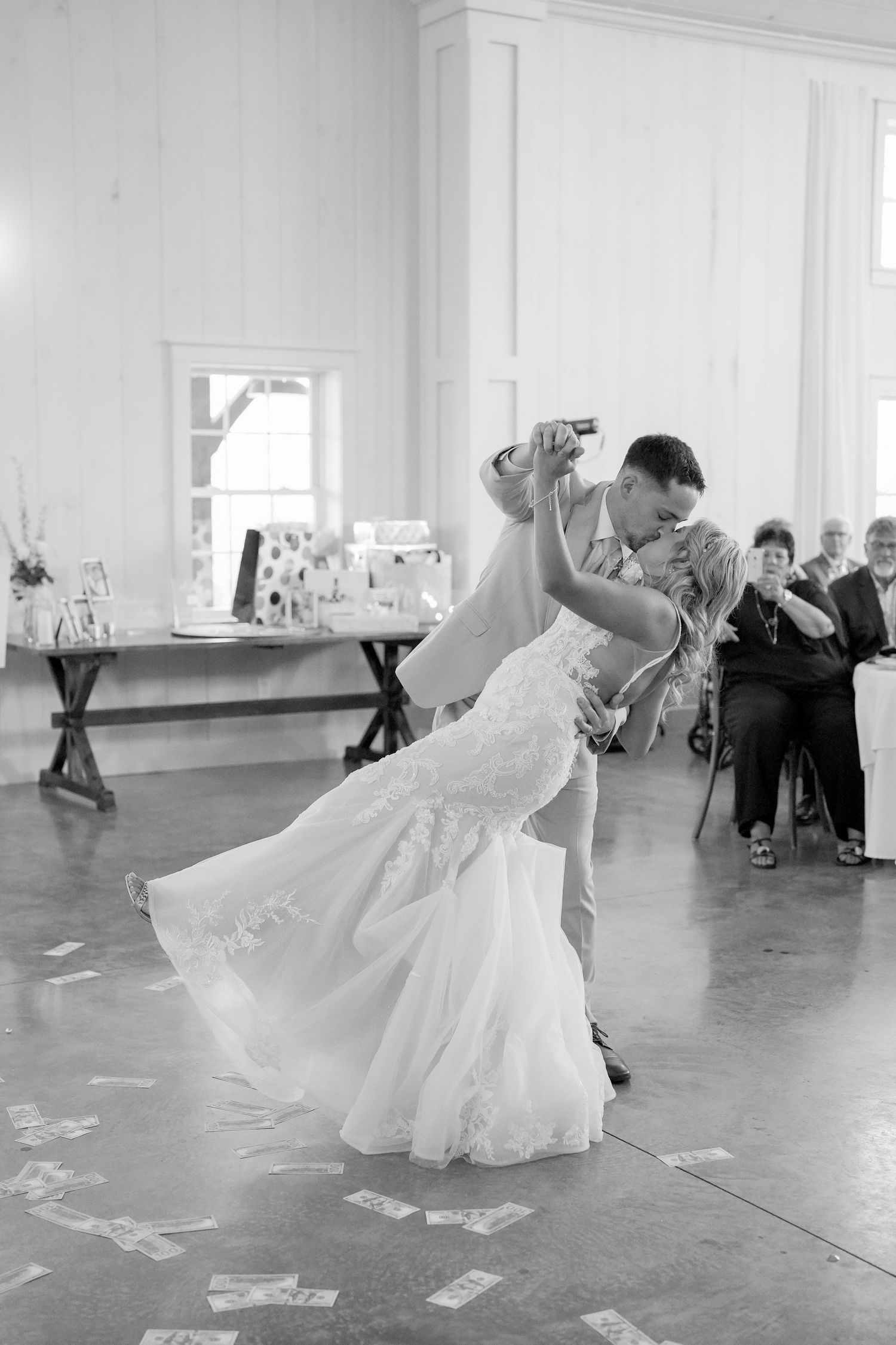 A romantic first dance at a wedding reception shows the couple in an elegant dip pose on the dance floor.