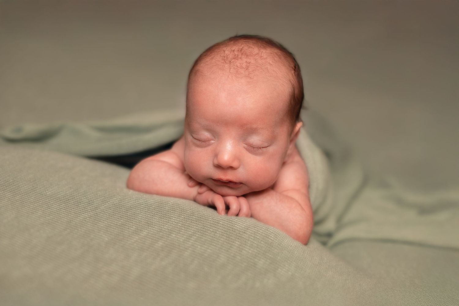 Close-up newborn photography with soft natural lighting and neutral tones.