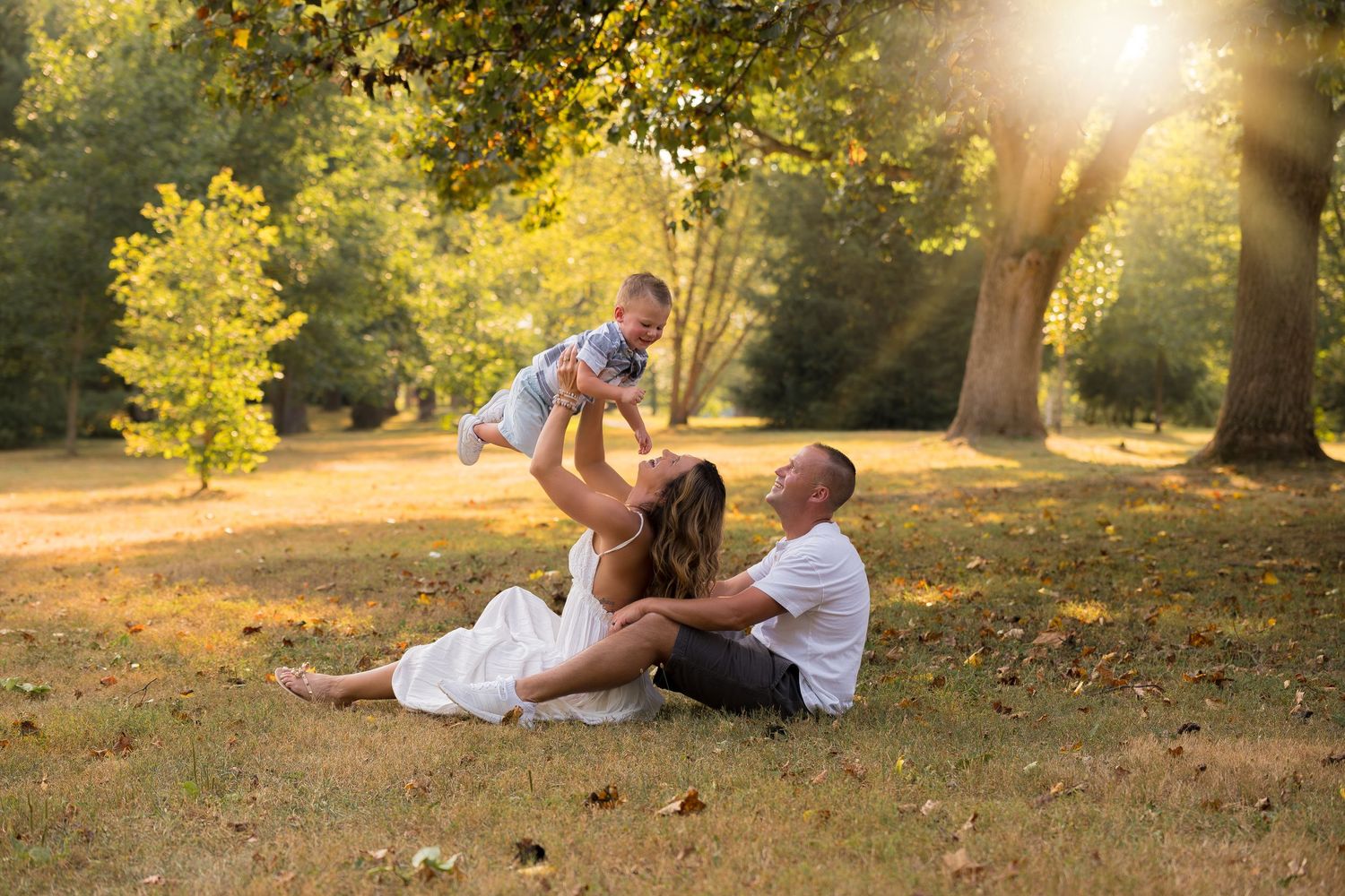 Candid family moments captured while relaxing on a grassy hill during sunset.