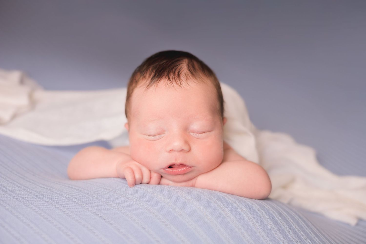 Artistic black and white newborn portraits on a simple backdrop.