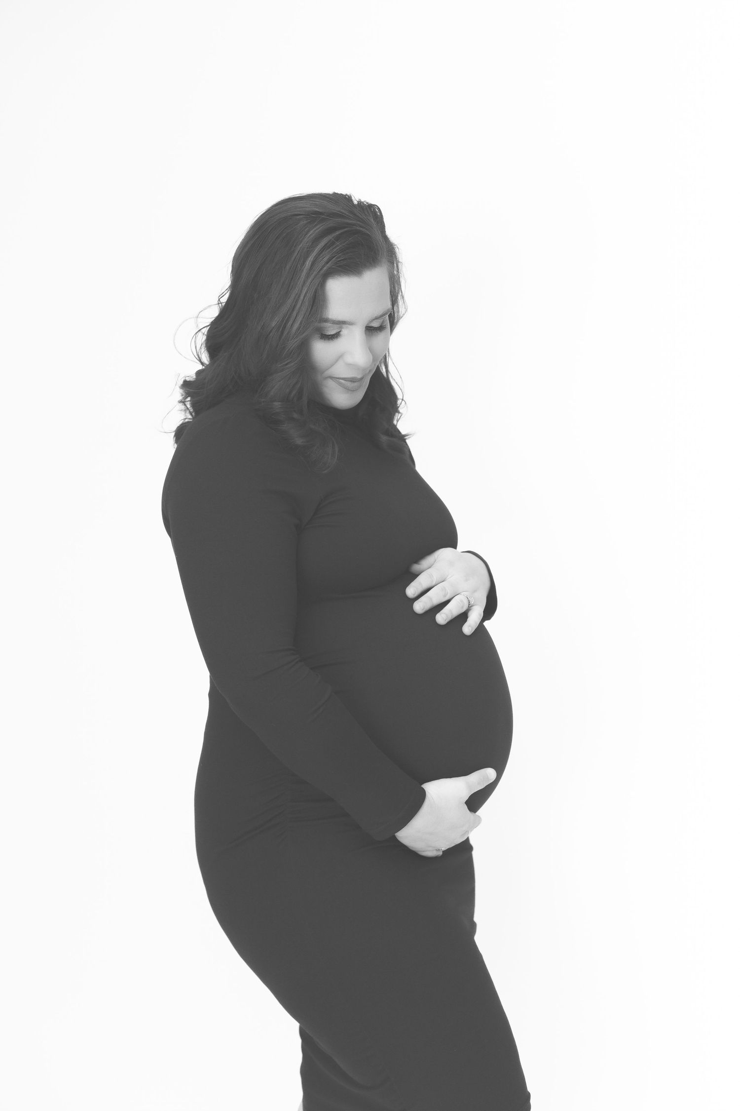 Studio maternity portraits in black against white background.