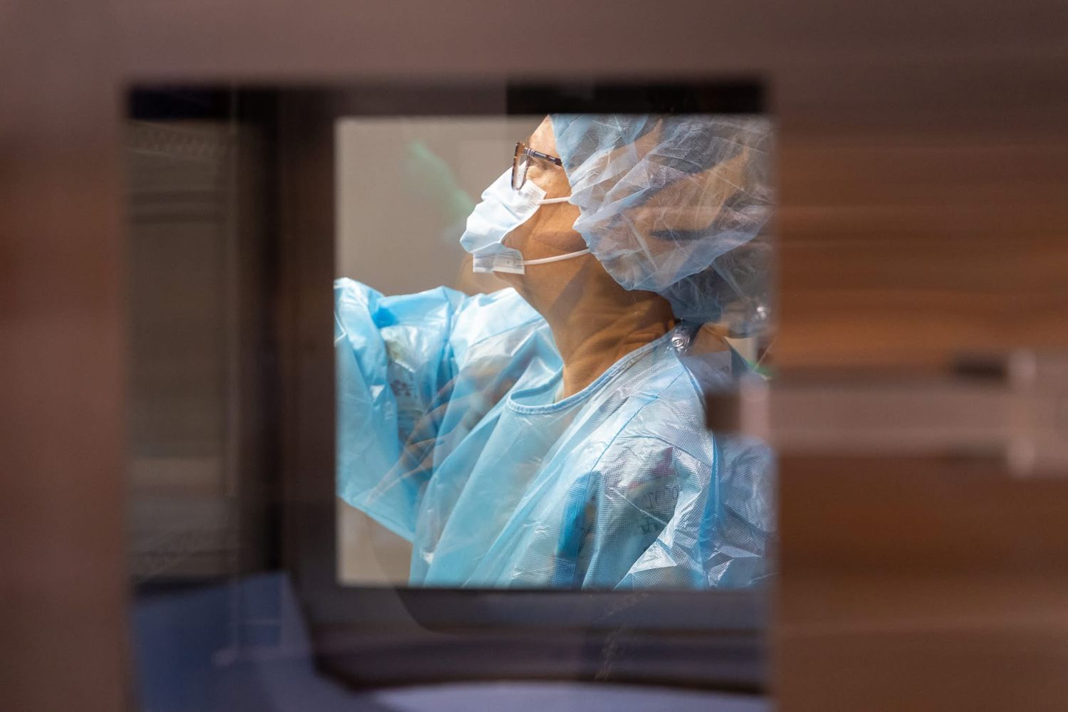 Healthcare workers in protective equipment working in a sterile medical environment.