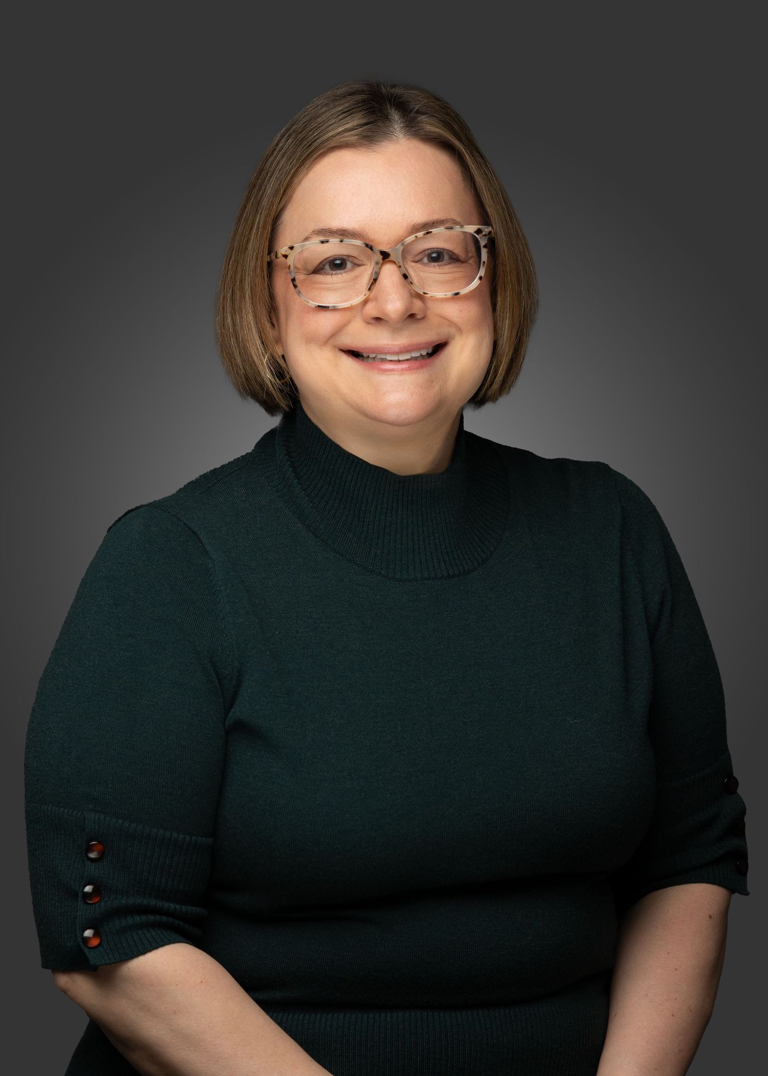 Professional studio portraits in a black turtleneck against a dark background.