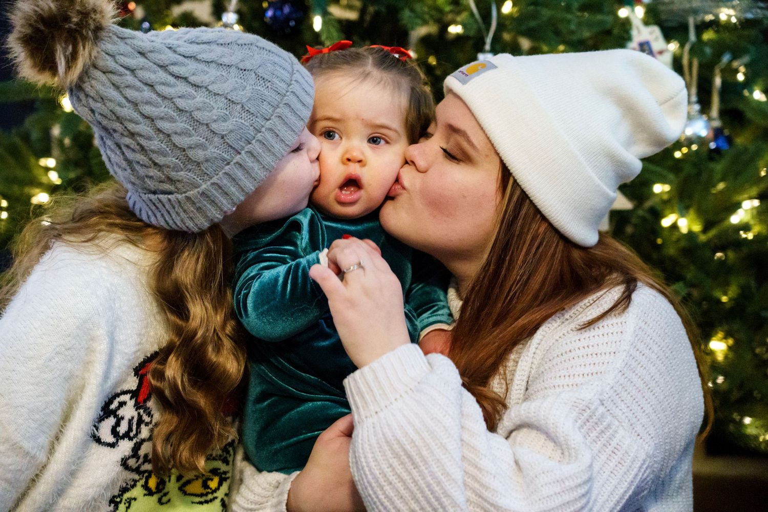 Winter scene of affectionate moments in front of a decorated Christmas tree.