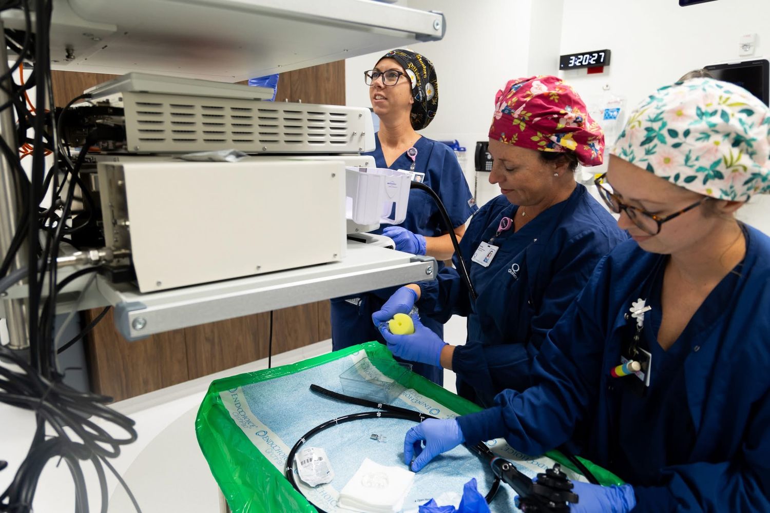 Healthcare professionals in blue scrubs working at stations with medical equipment.