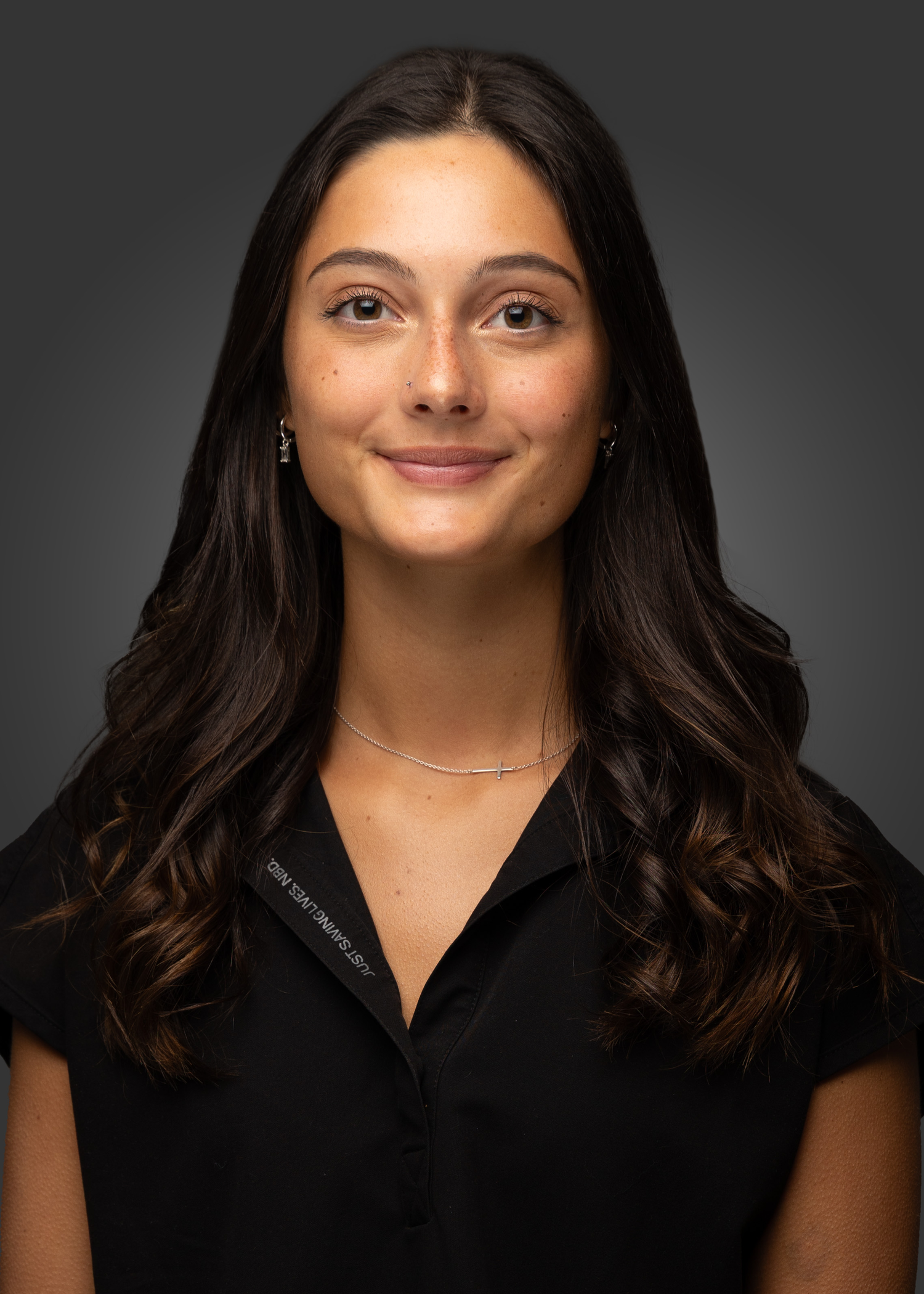Studio portrait with dark background wearing black top.