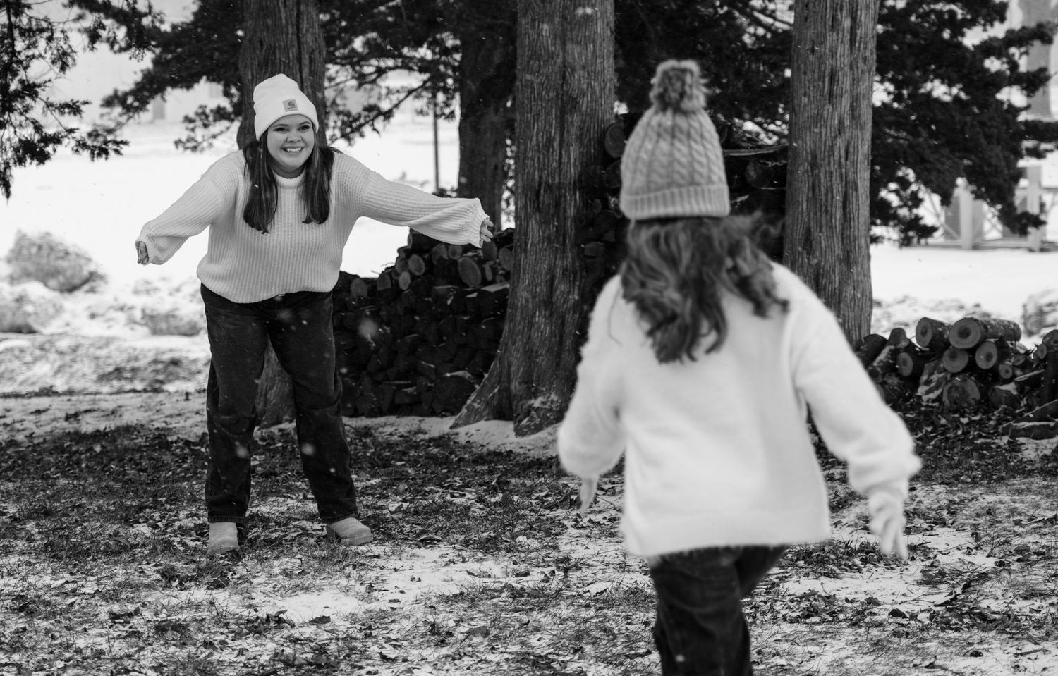 Family photoshoot in a snowy outdoor setting with pine trees in the background.