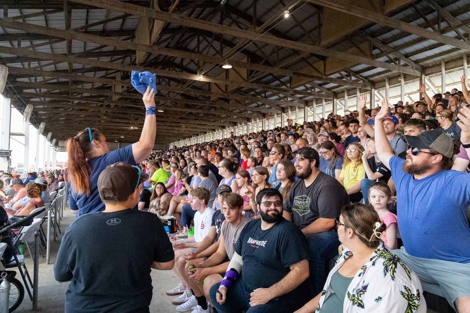 Wide panoramic view of spectators filling stadium seating at outdoor event.