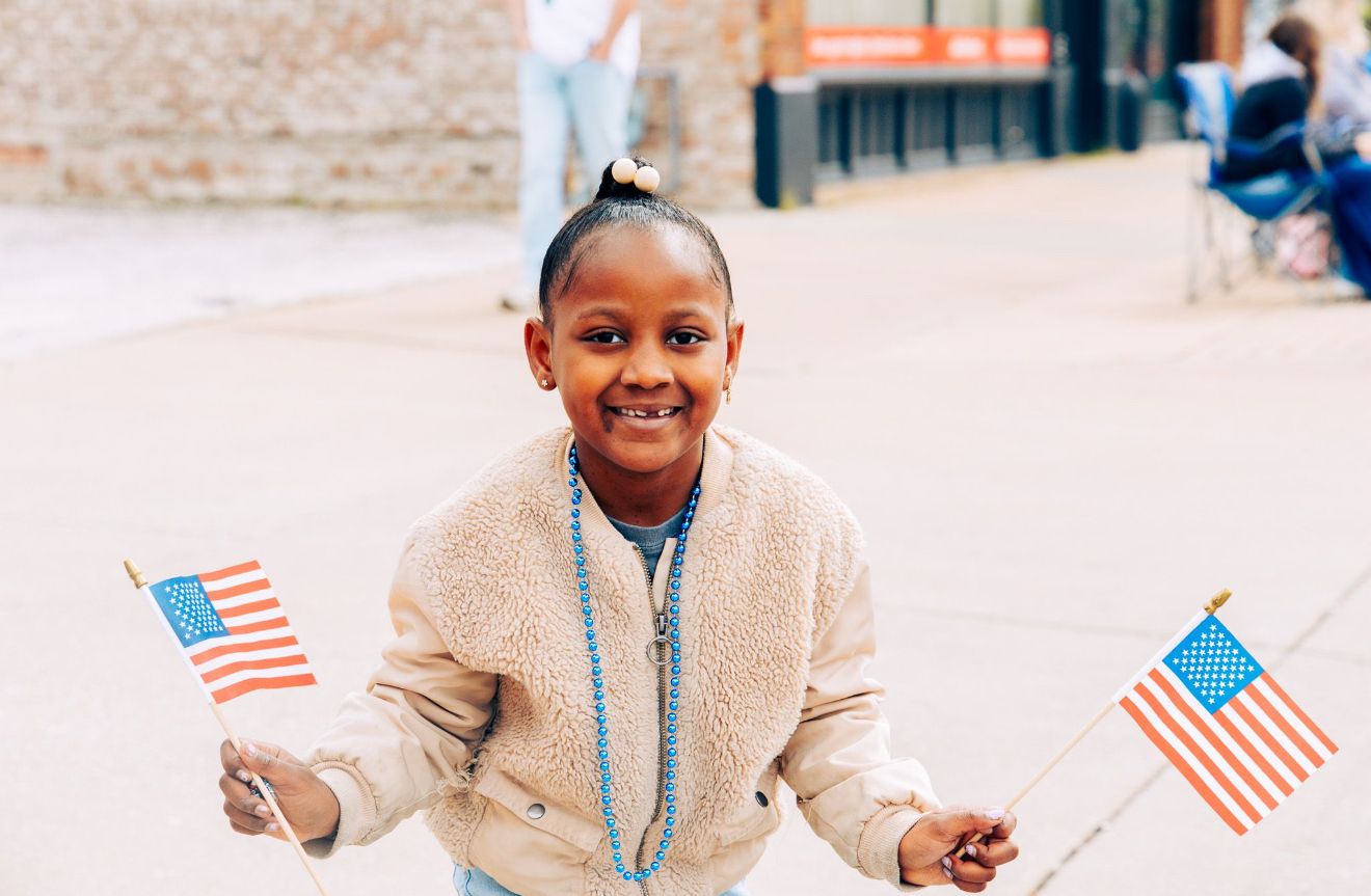 Small American flags displayed in a row at an outdoor event.