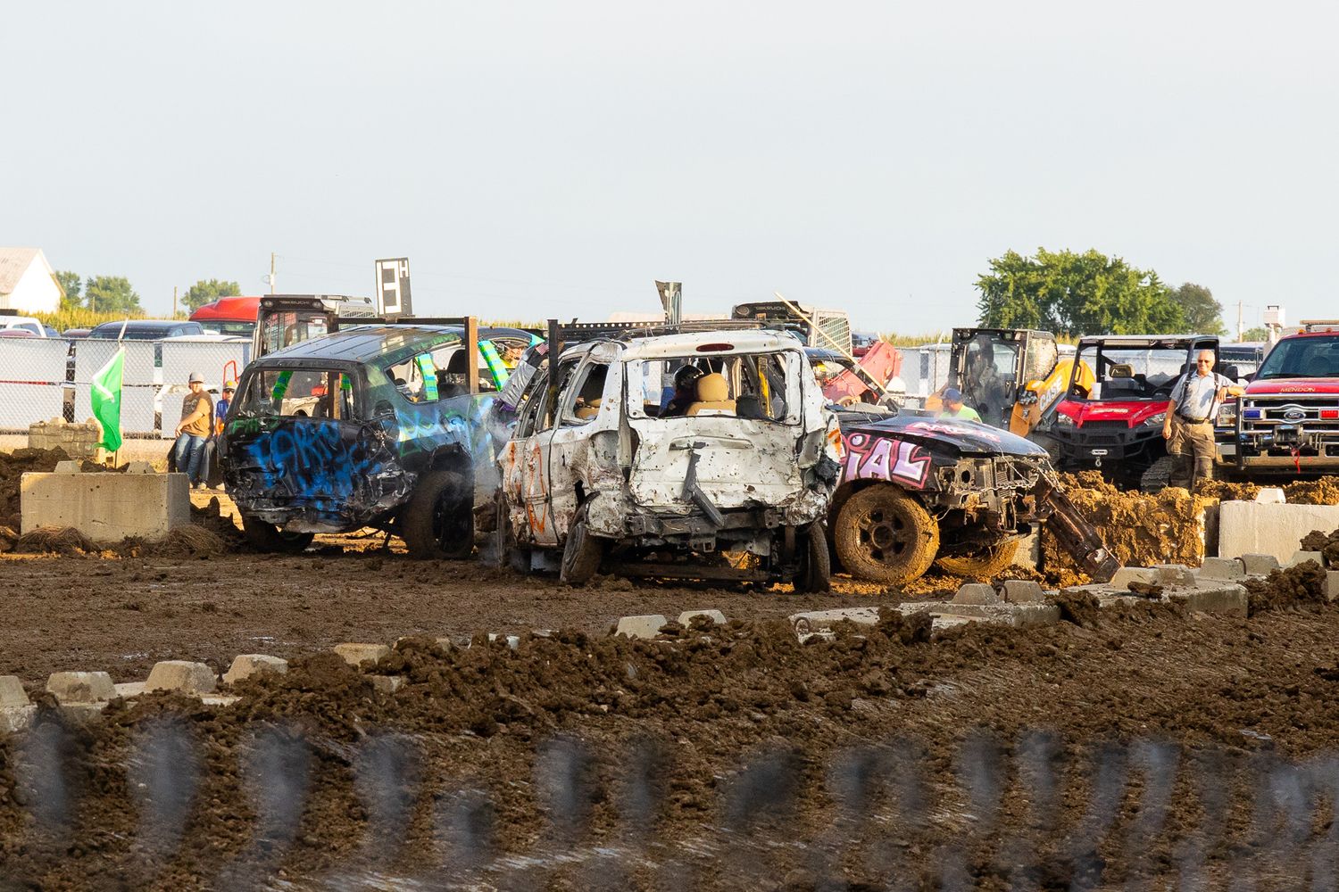 Aerial view of muddy construction or demolition site with equipment and debris visible.