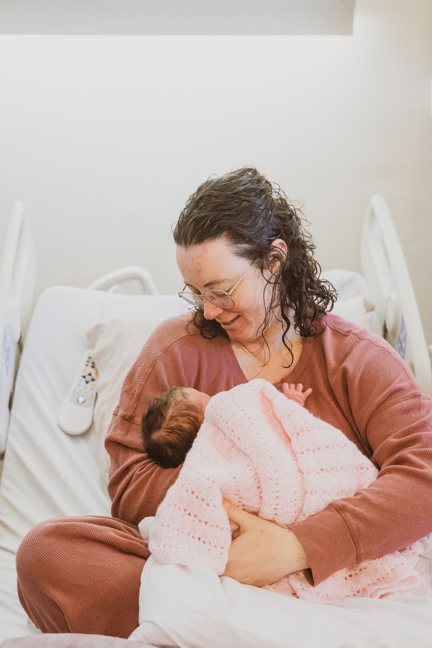 A heartwarming scene of a parent bonding with their newborn in a hospital bed.