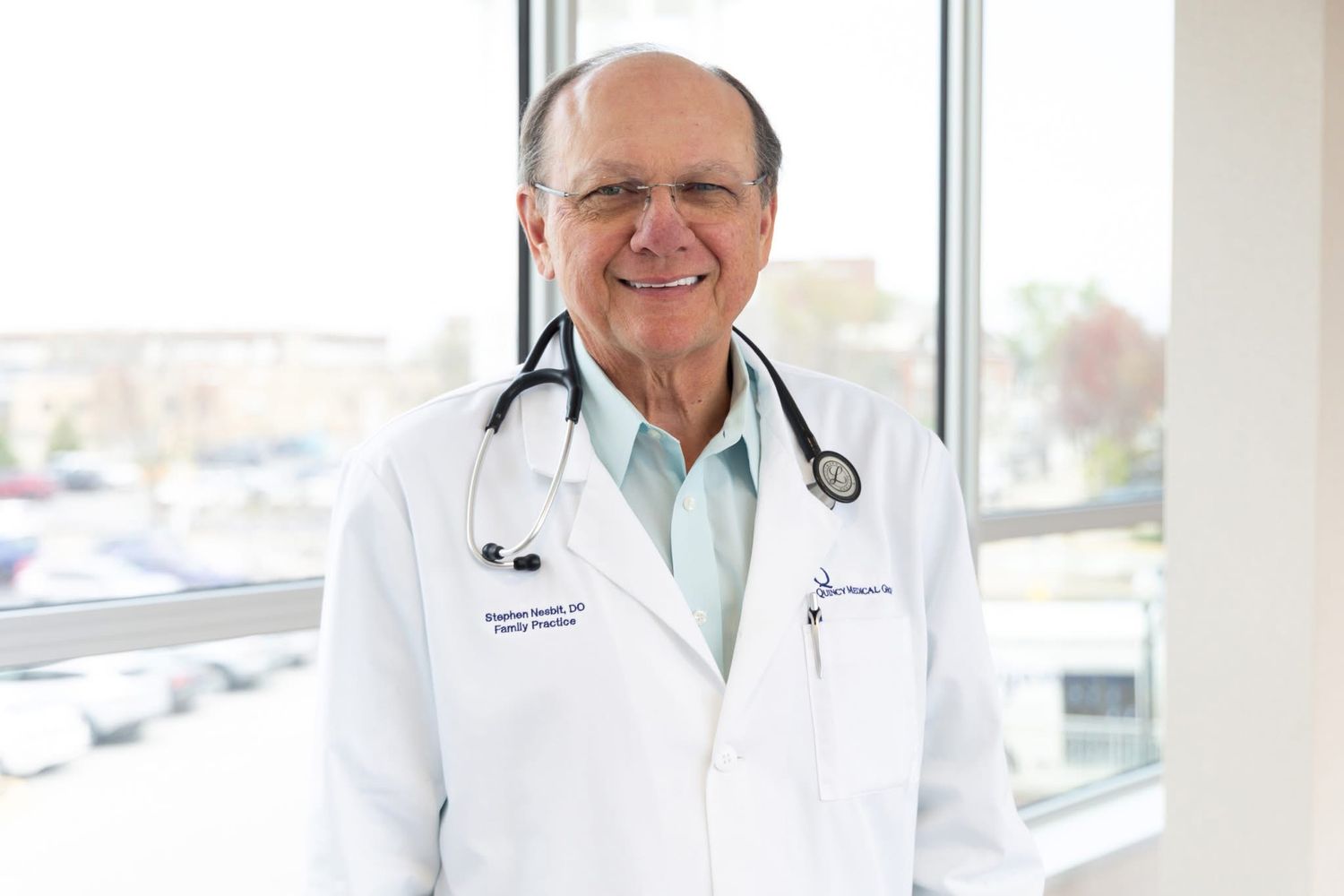 Medical professionals in white coats by windows in a modern healthcare facility.