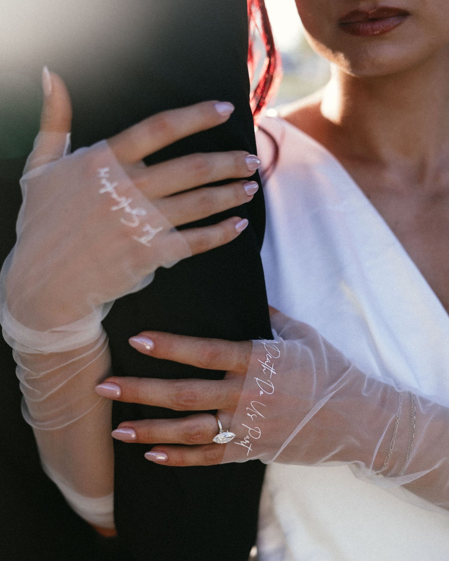 Delicate sheer white gloves are displayed in a series of elegant poses against a dark background.