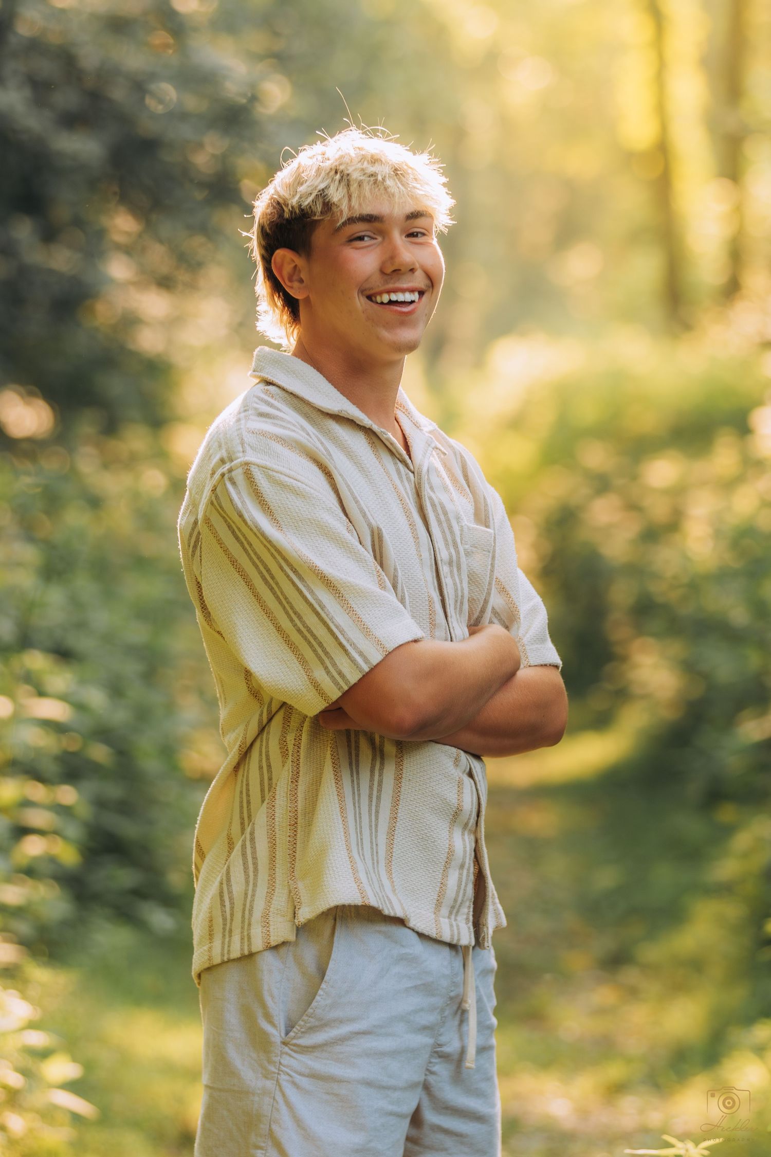 Senior smiling with arms crossed.