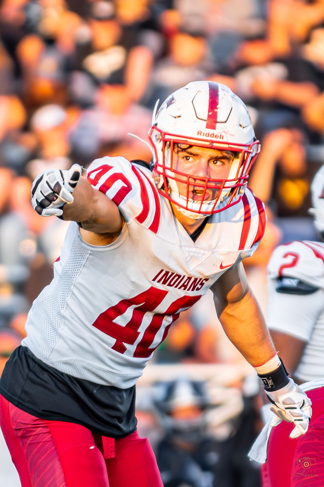 Football player getting into stance pointing at camera with a serious face on.
