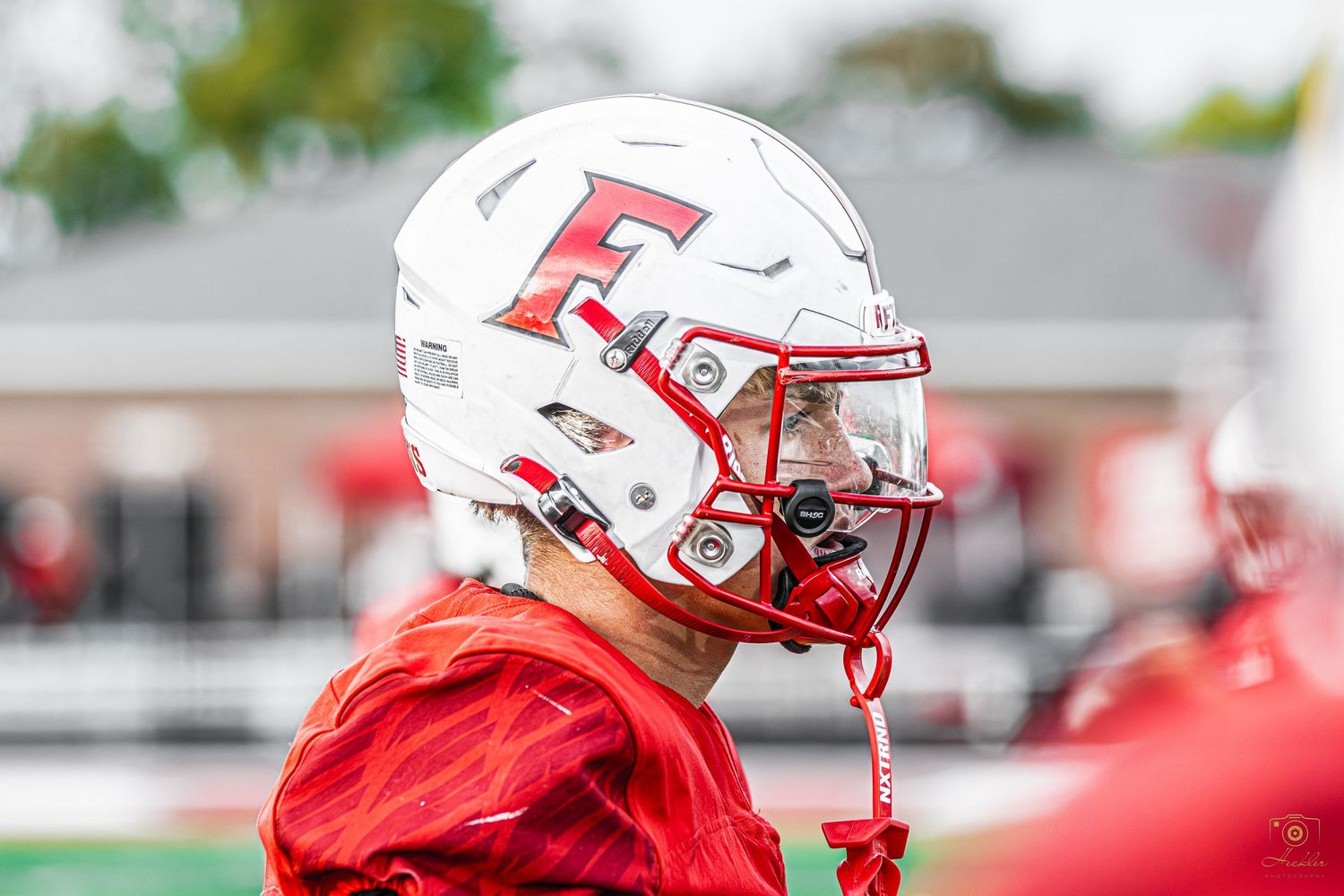 Football players side of face while walking.