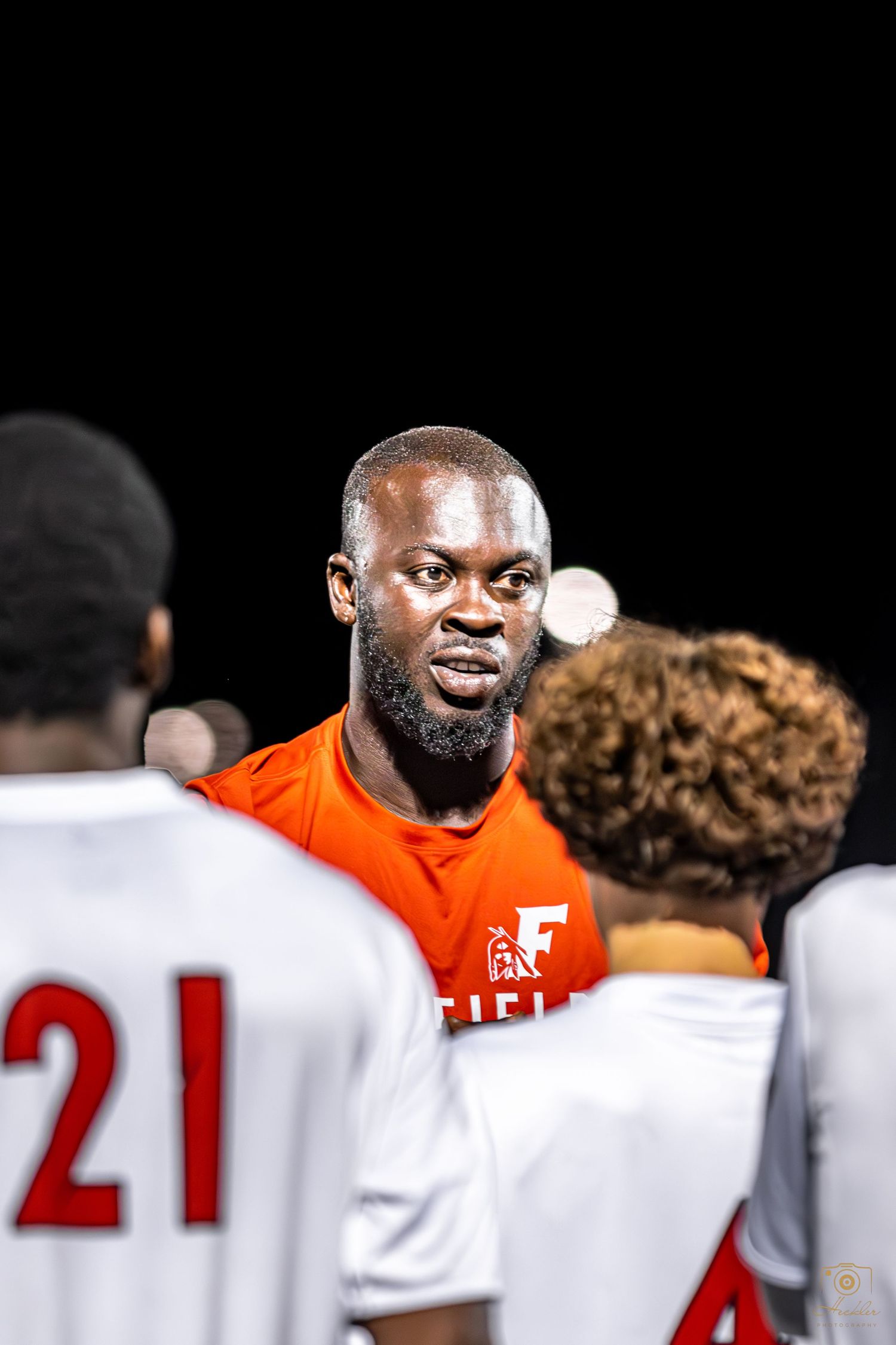 Soccer coach talking to team during halftime.
