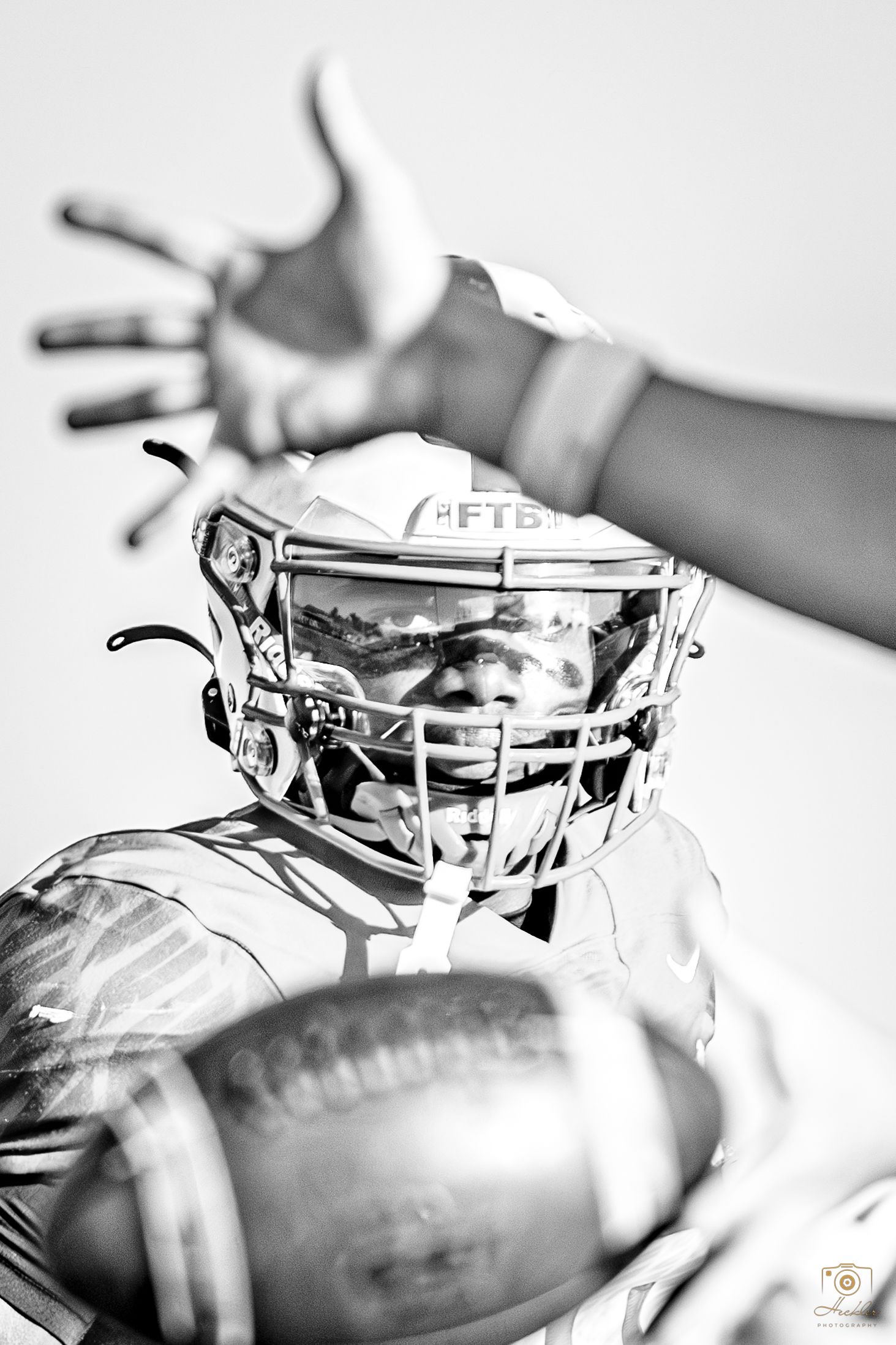 Football player looking at camera framed between another player.