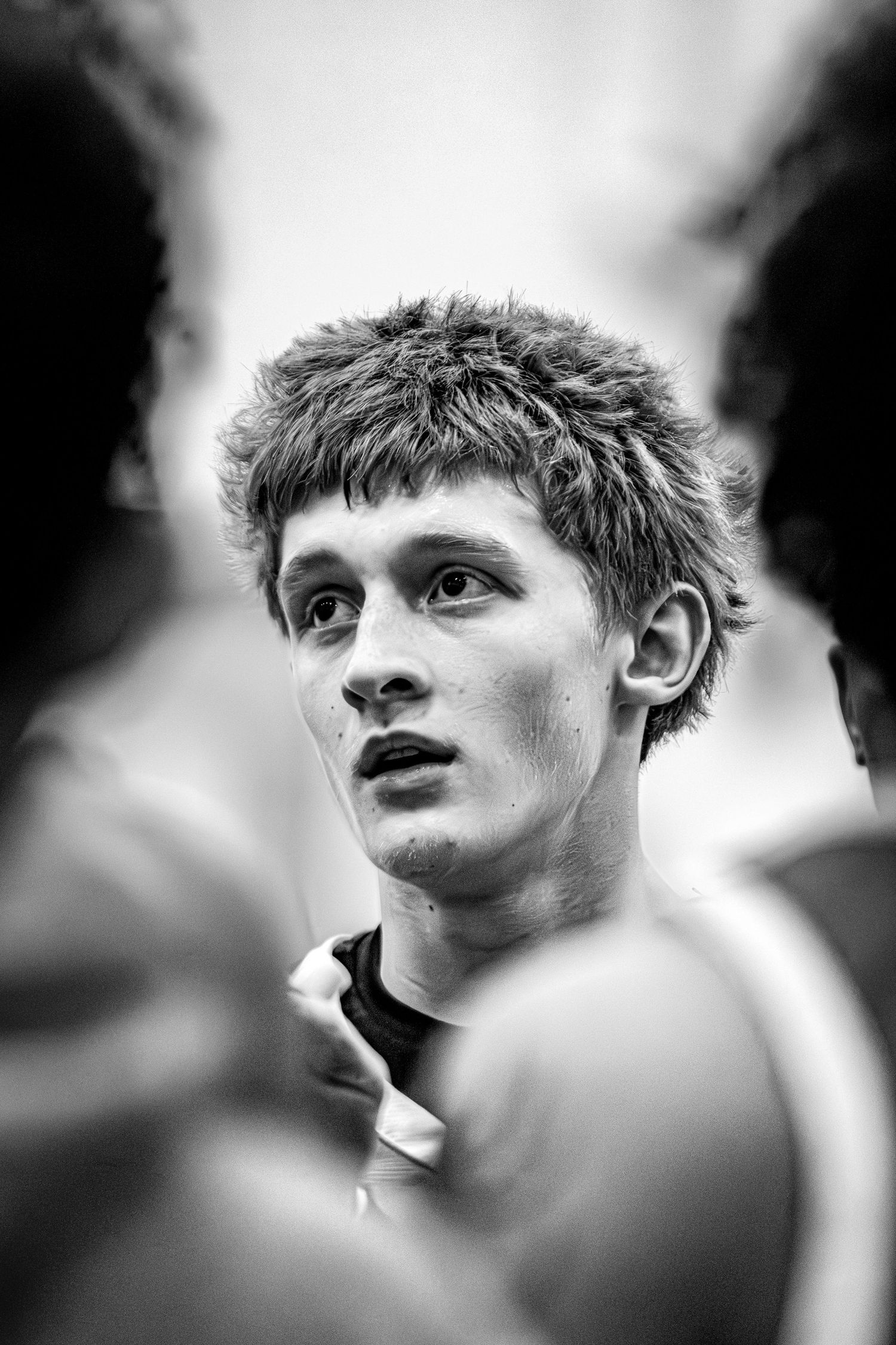 Basketball player looking coach up close in B&W.