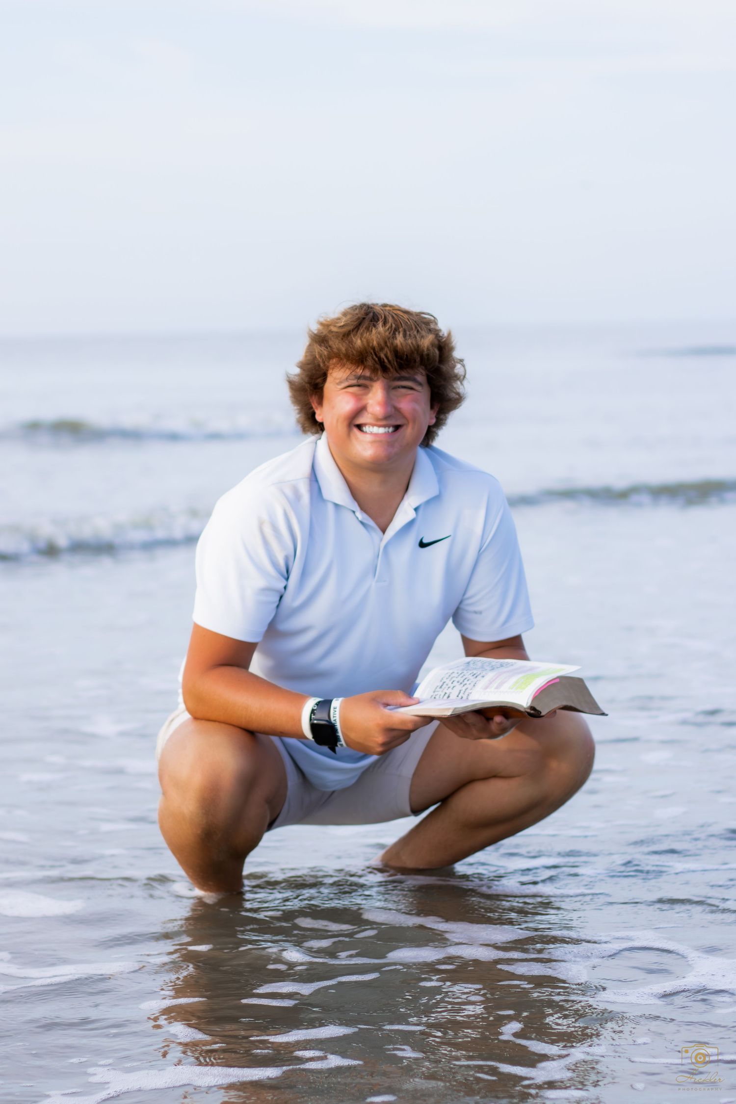 Photographer with a bible in the ocean.