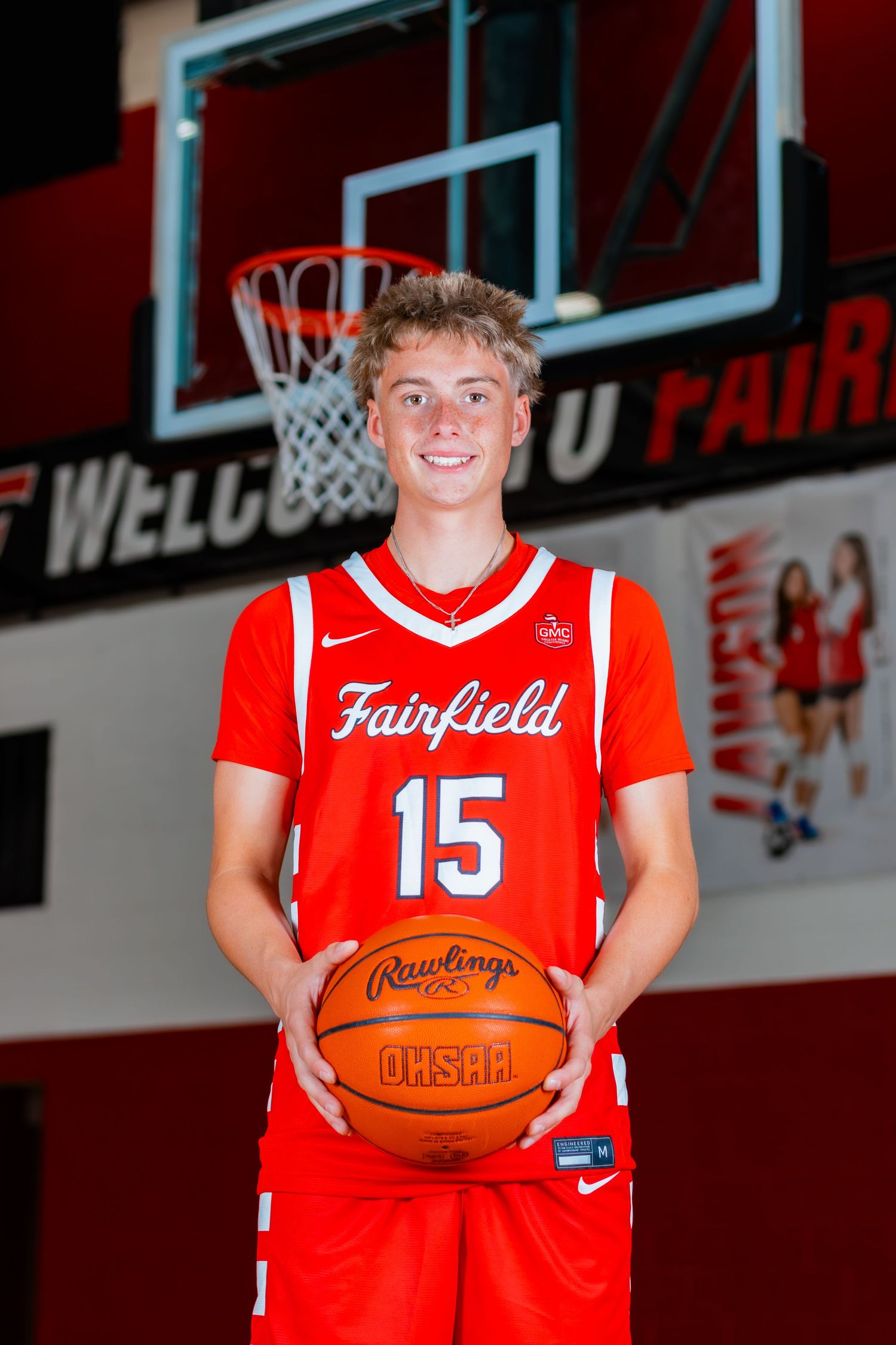 Basketball senior holding ball while having a big smile at camera.