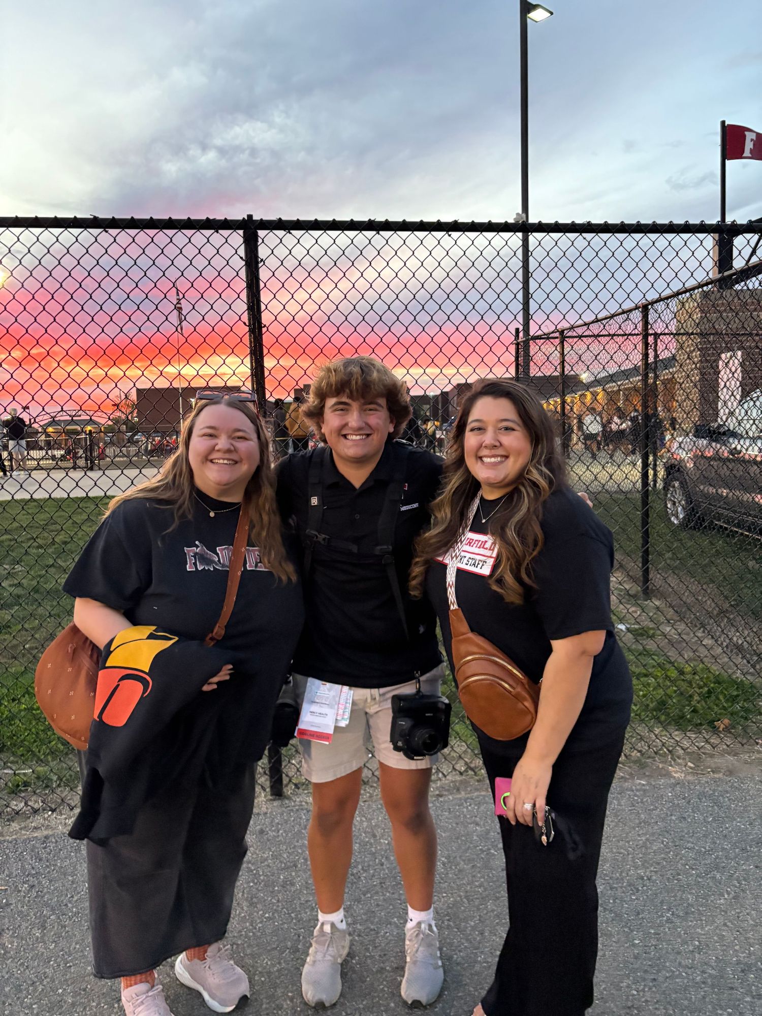 2 people at a football game with a cool sunset.