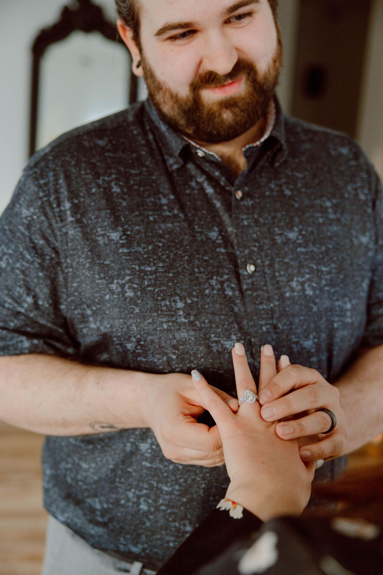 Close-up shot of hands with ring in indoor setting.