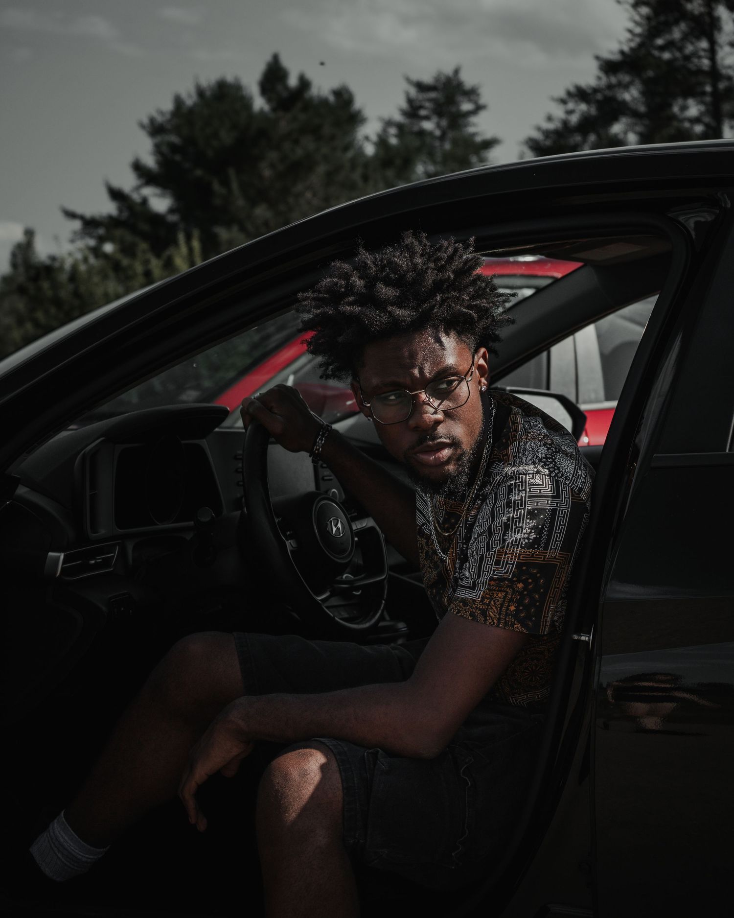 Moody portrait series of person sitting in black car with dramatic lighting and dark atmosphere.
