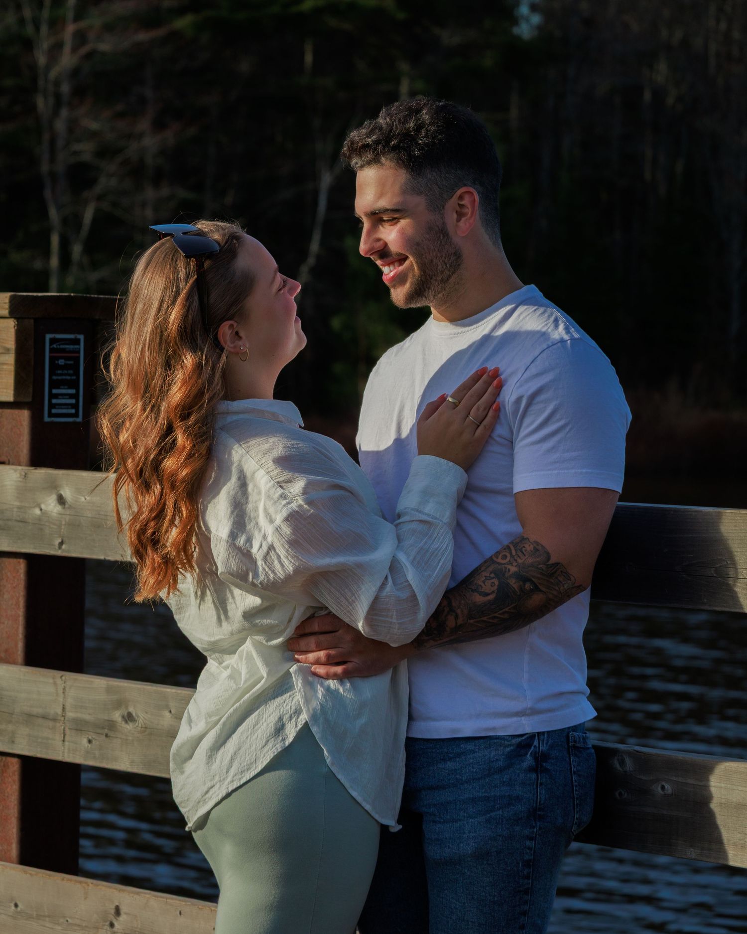A couple shares an intimate moment together on a dock during sunset.
