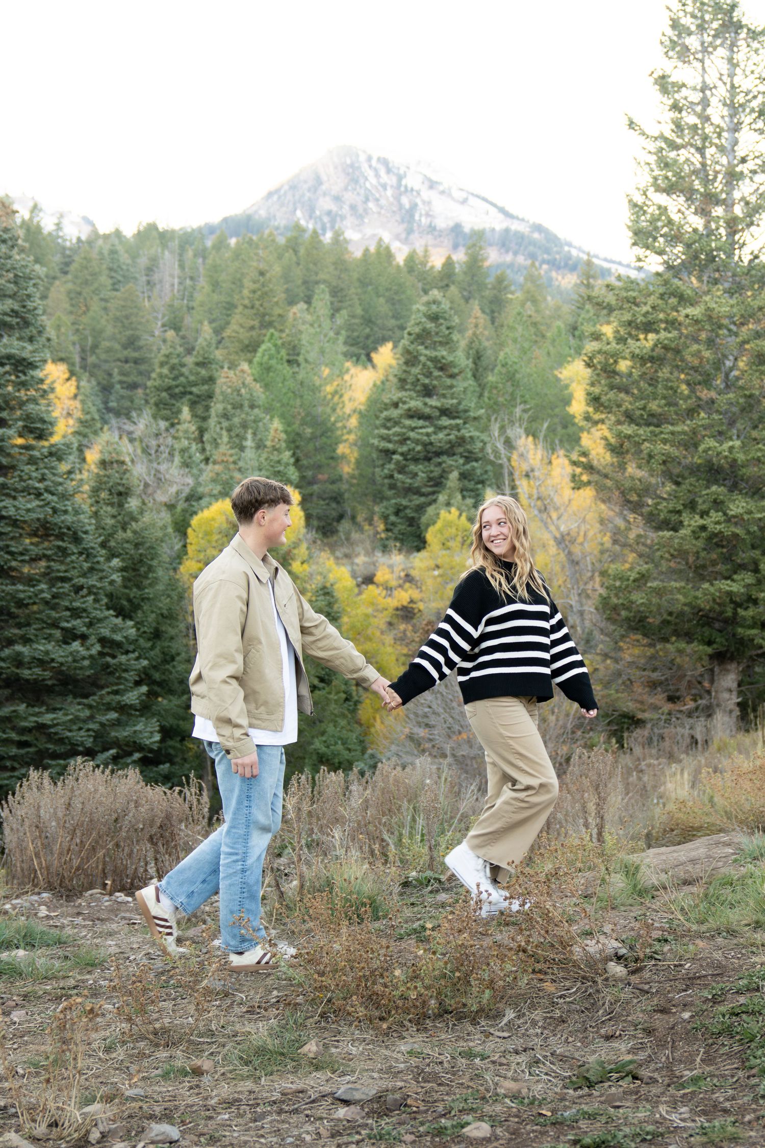 Utah mountain engagement photoshoot with couple smiling and holding hands