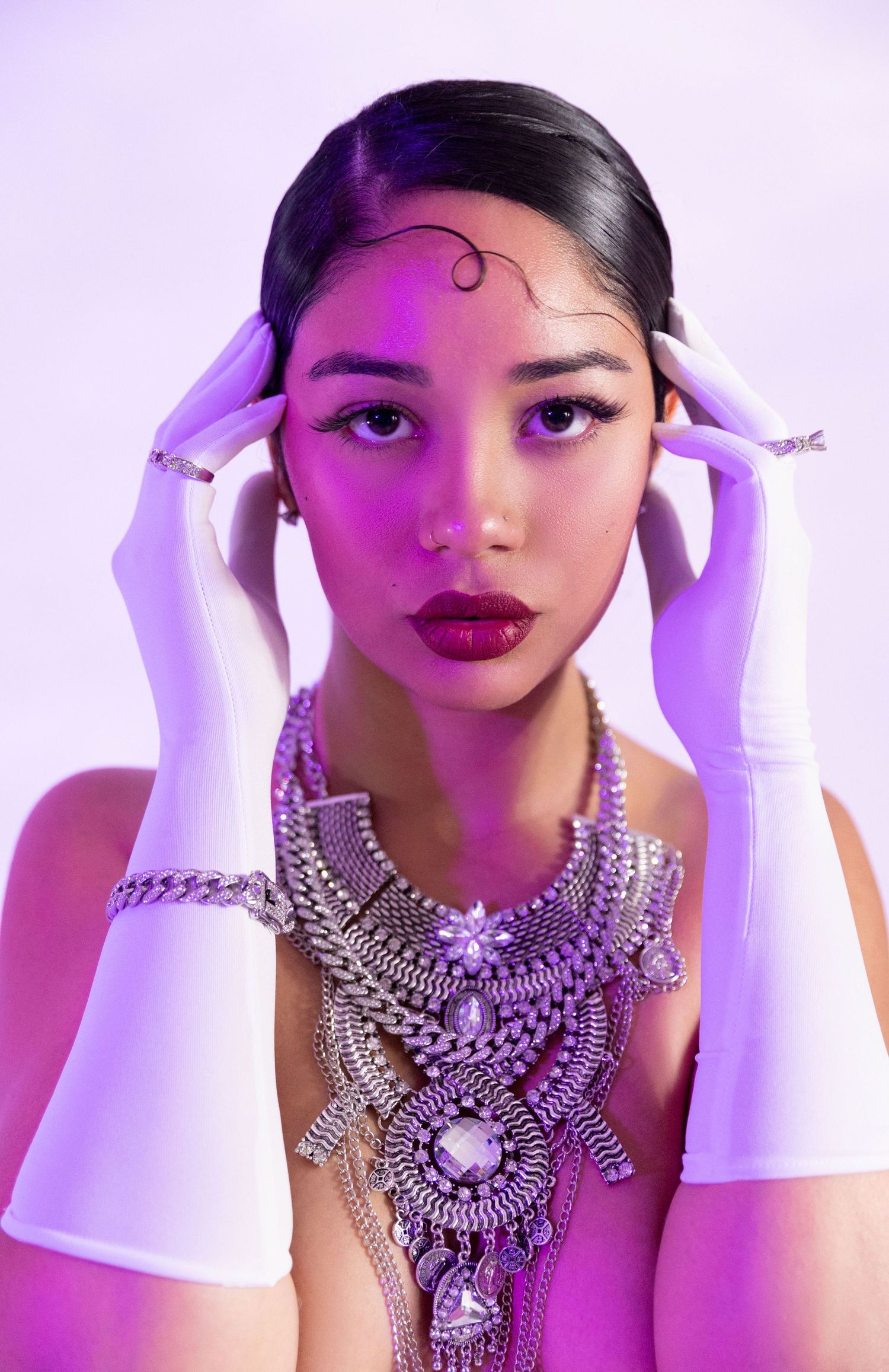 Portrait of a woman wearing bold, maximalist jewelry pieces with colorful styling and confident expression.