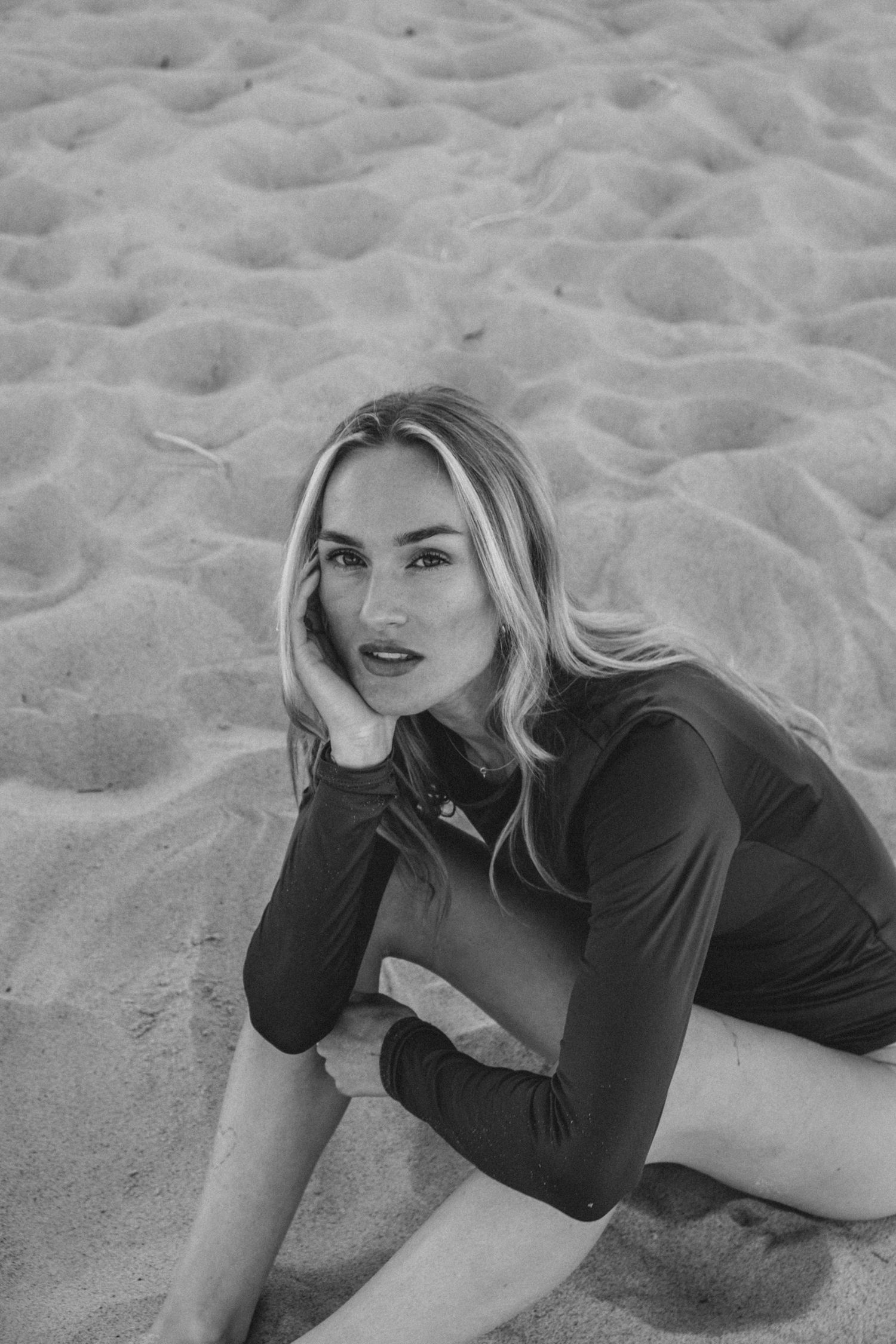 Artistic black and white portrait on sandy beach with dramatic poses.