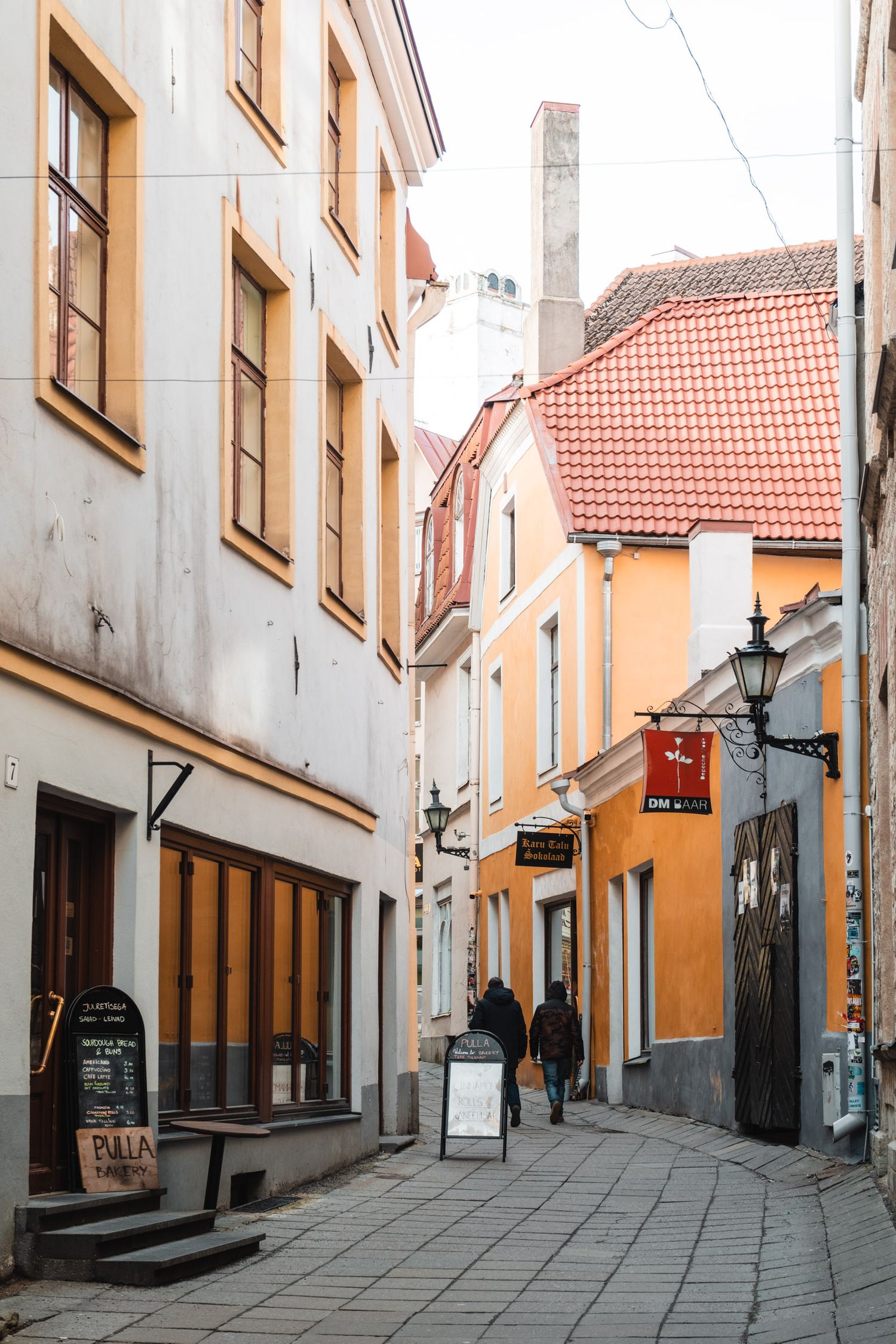 Narrow cobblestone street lined with historic buildings and traditional architecture in an old European town.