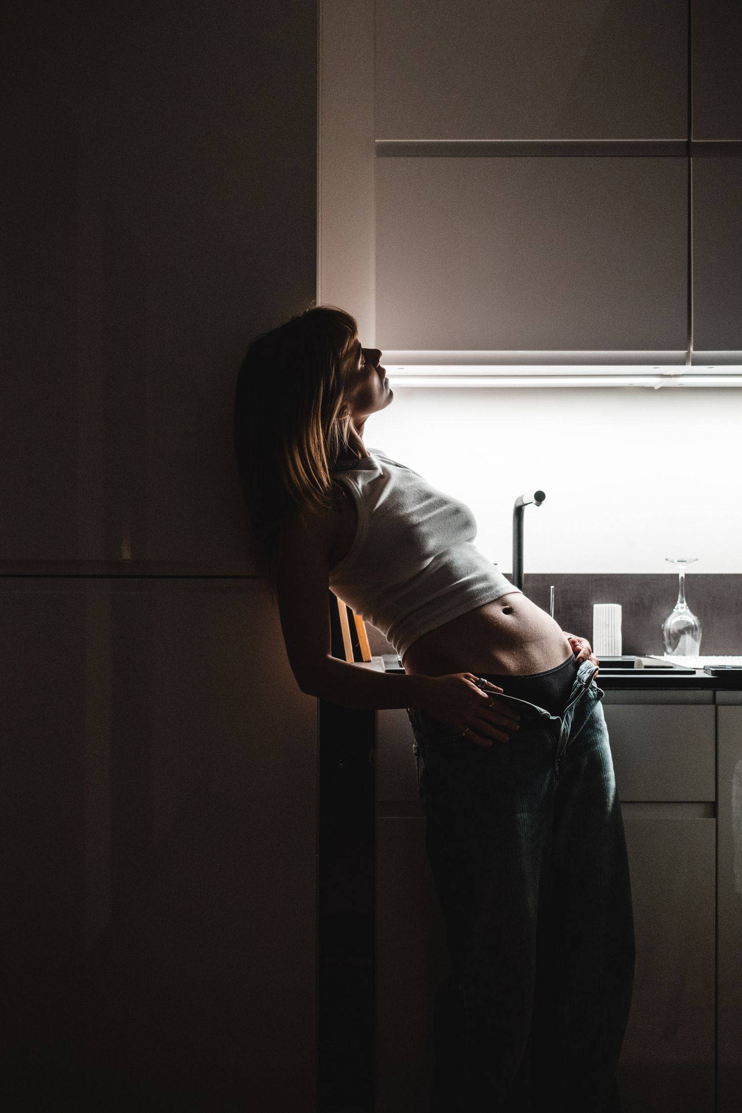 Silhouette of someone in a kitchen illuminated by natural window light.