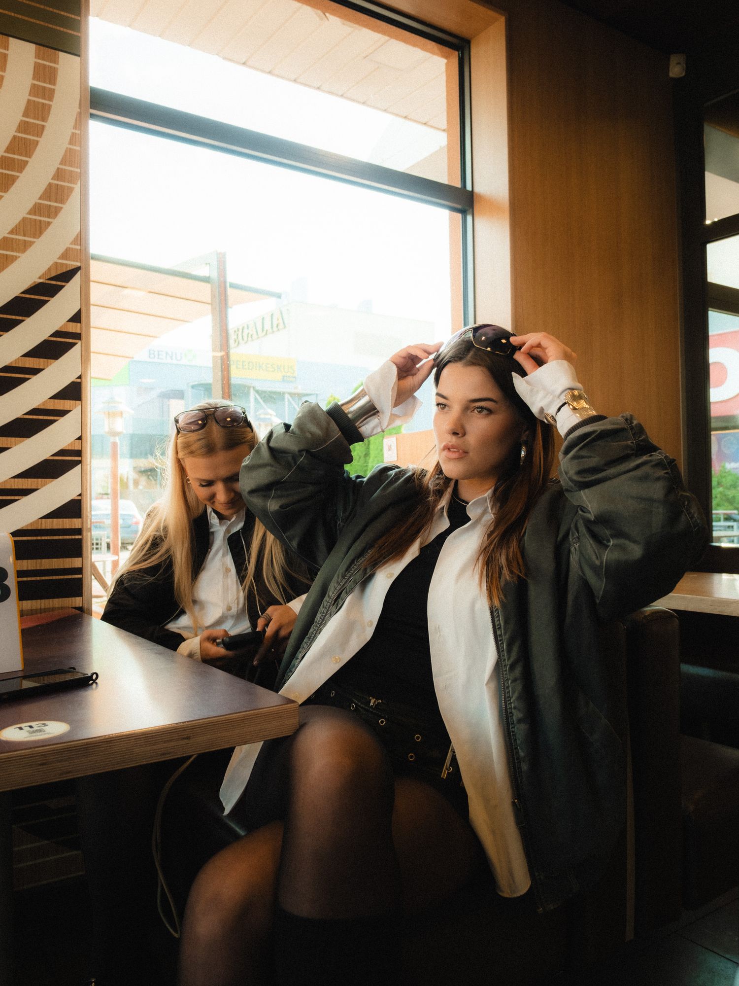 Fashion shoot in modern interior with natural window lighting and leather jacket styling.