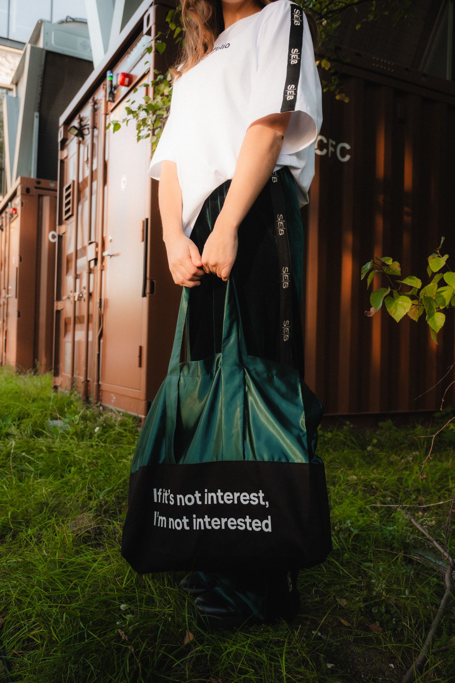 A sequence of photos showing a person carrying a black and green tote bag with text reading 'I'm not interested' on it.