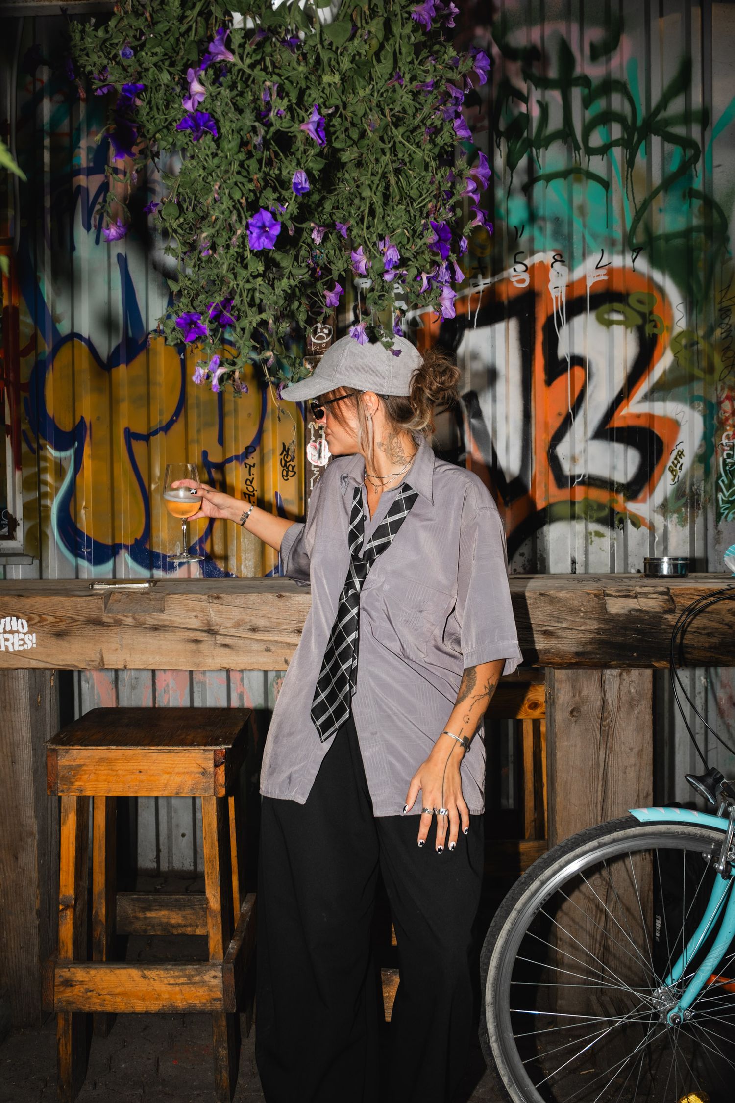 Urban scene with purple flowers and graffiti wall featuring casual interactions.