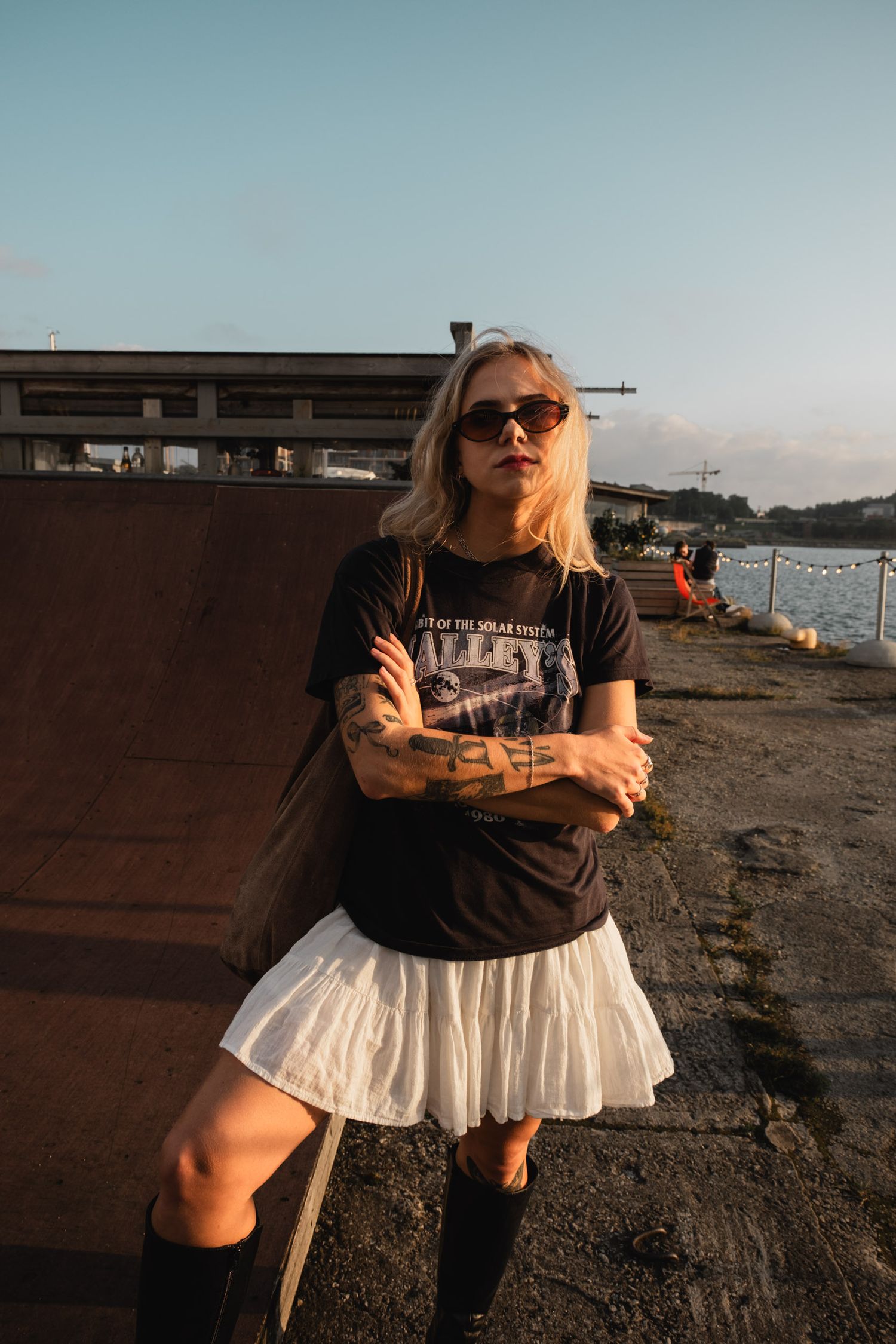 A street style pose against an industrial waterfront backdrop.