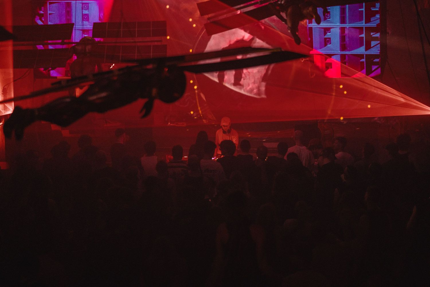 Nightclub scene with red and blue lighting creating dramatic atmosphere.