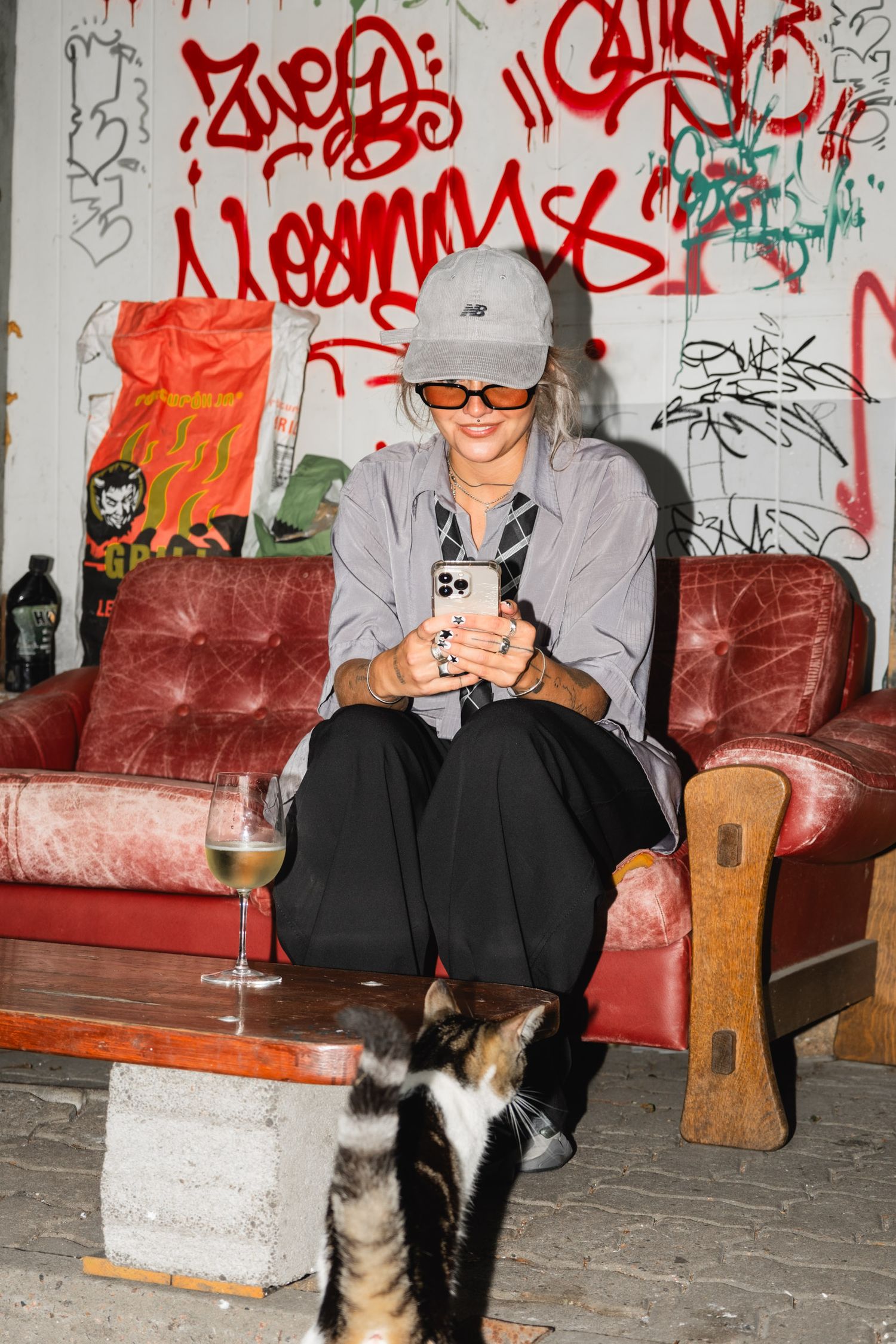 Graffiti-covered wall setting with red sofa and casual indoor scene.