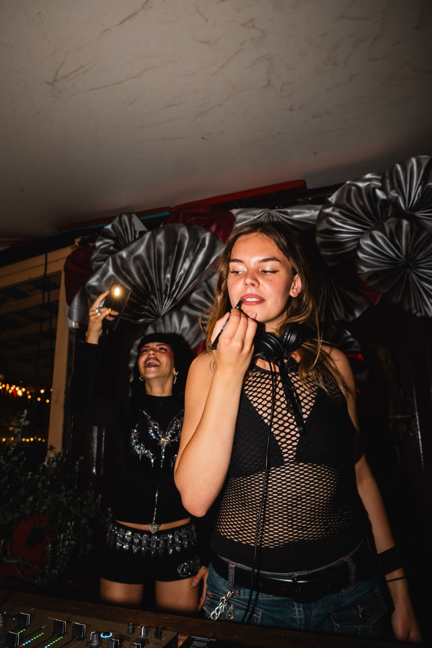 People dancing and enjoying music in a dark nightclub setting with dramatic lighting.