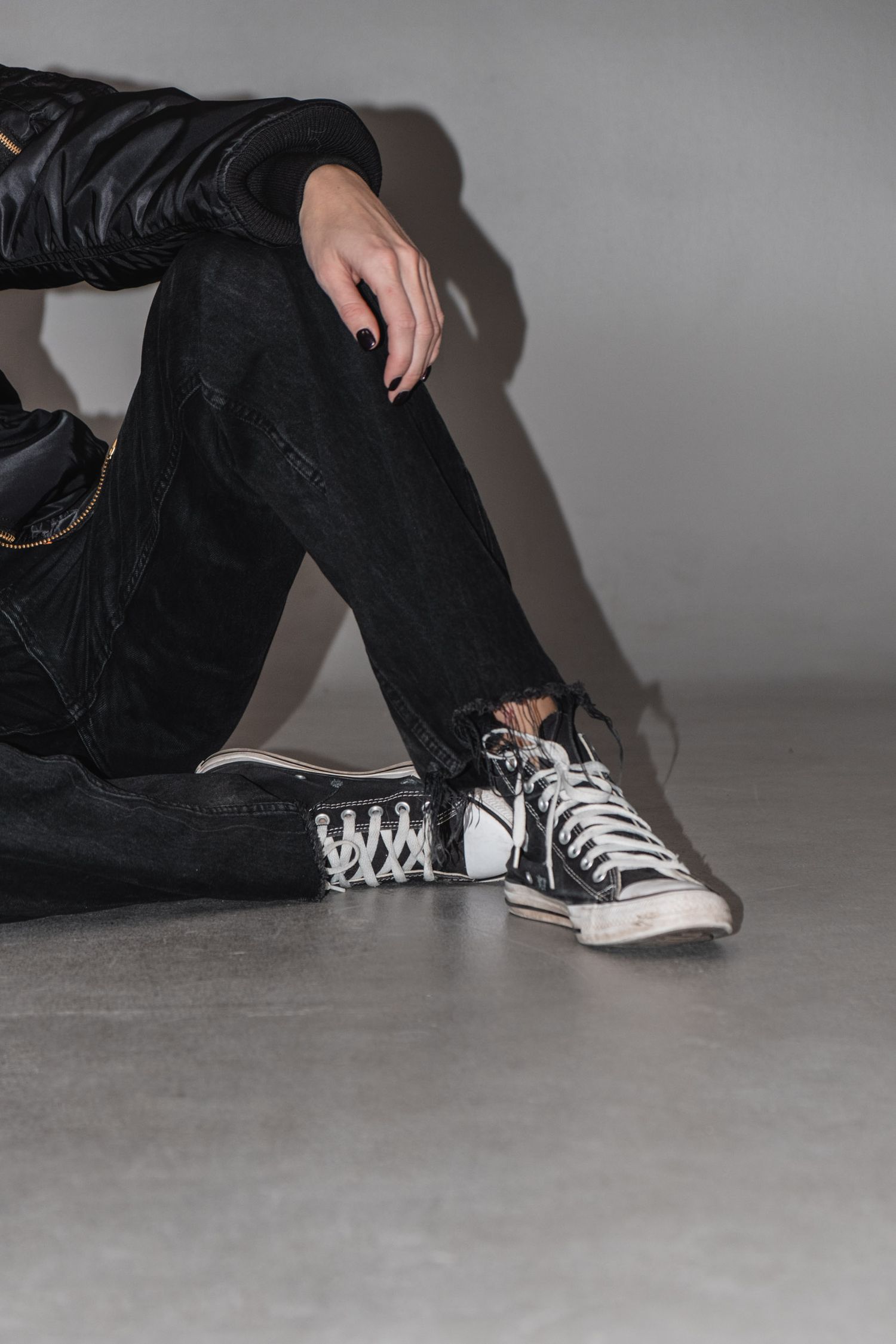 Close-up of classic black and white sneakers on grey floor.